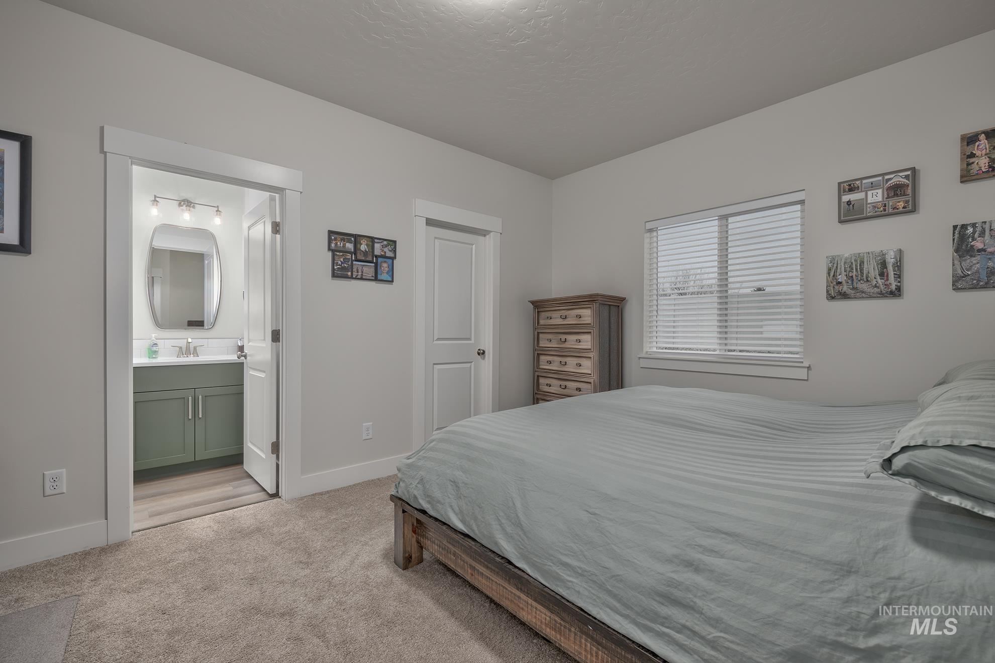 Bedroom featuring light colored carpet and a textured ceiling