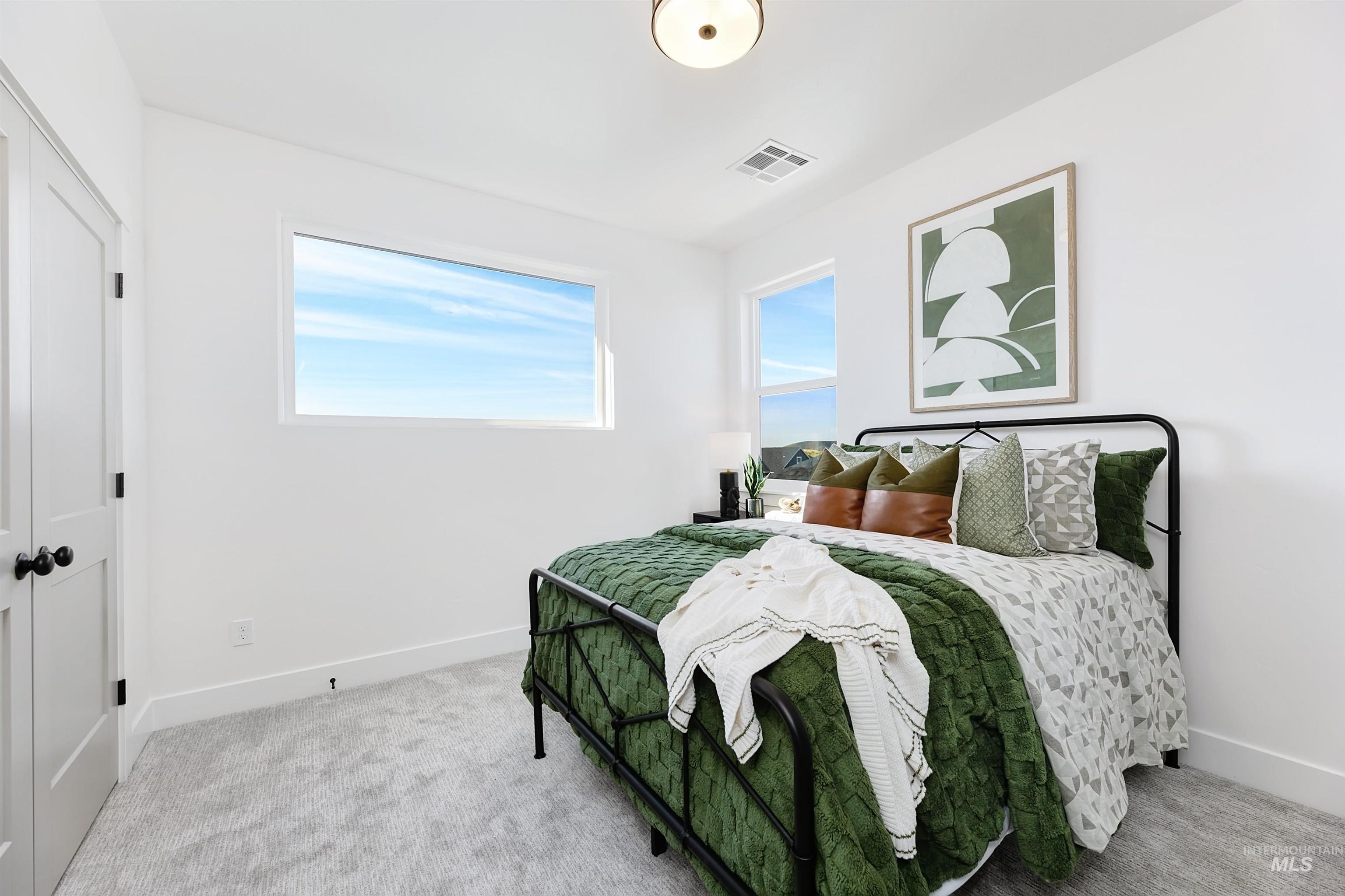 Bedroom featuring light carpet and baseboards
