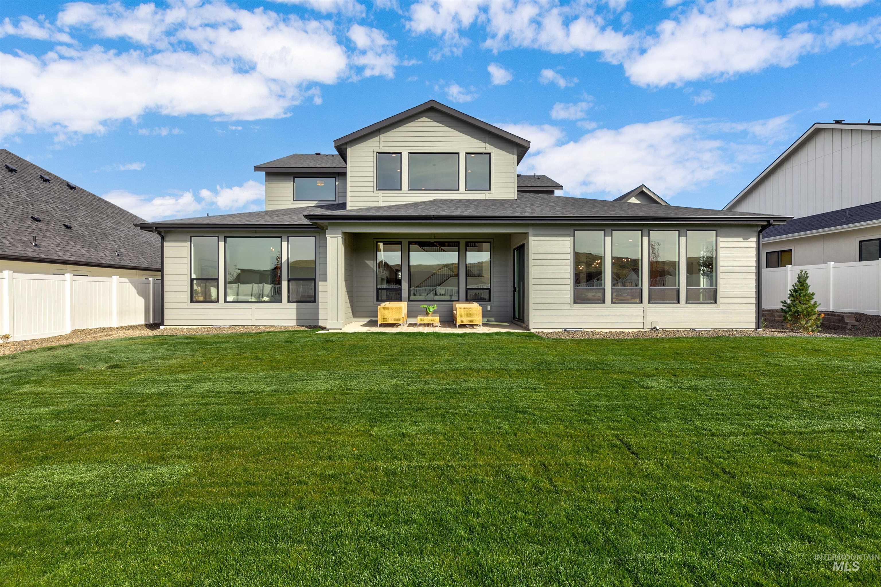 Back of house with a fenced backyard, a patio area, and a shingled roof