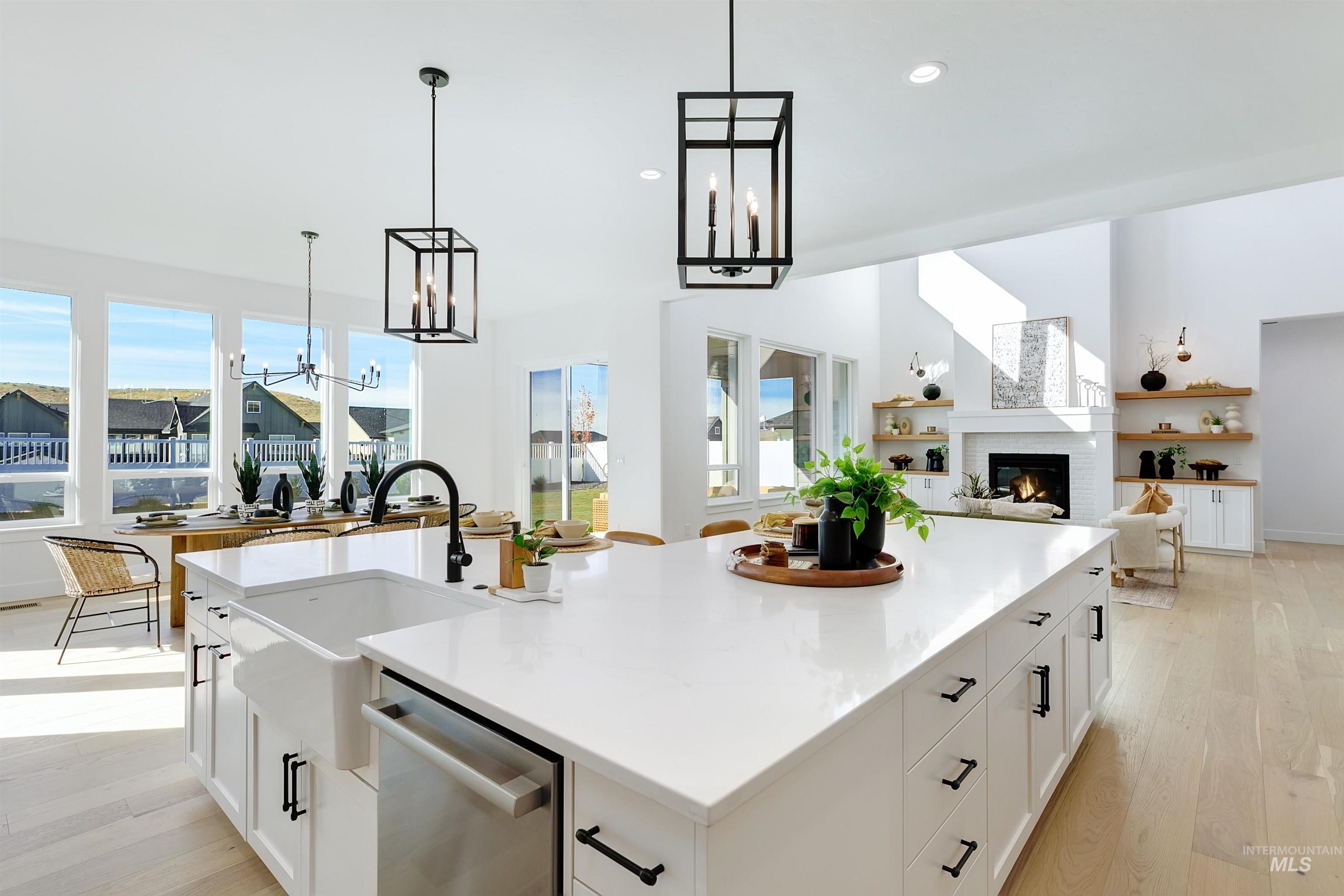 Kitchen with white cabinetry, light wood-type flooring, open floor plan, and a fireplace