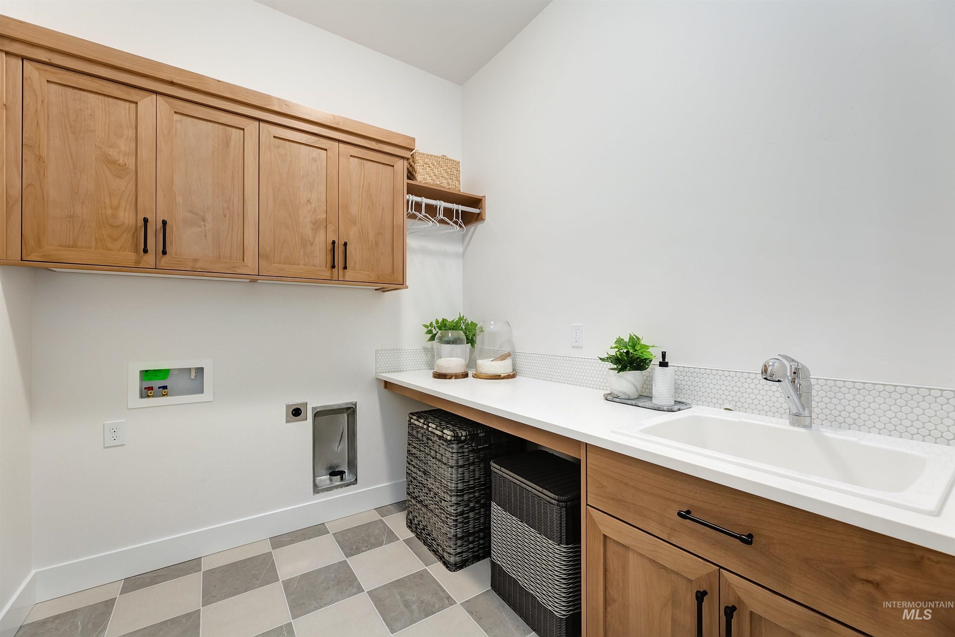 Laundry area featuring electric dryer hookup, light floors, hookup for a washing machine, and cabinet space