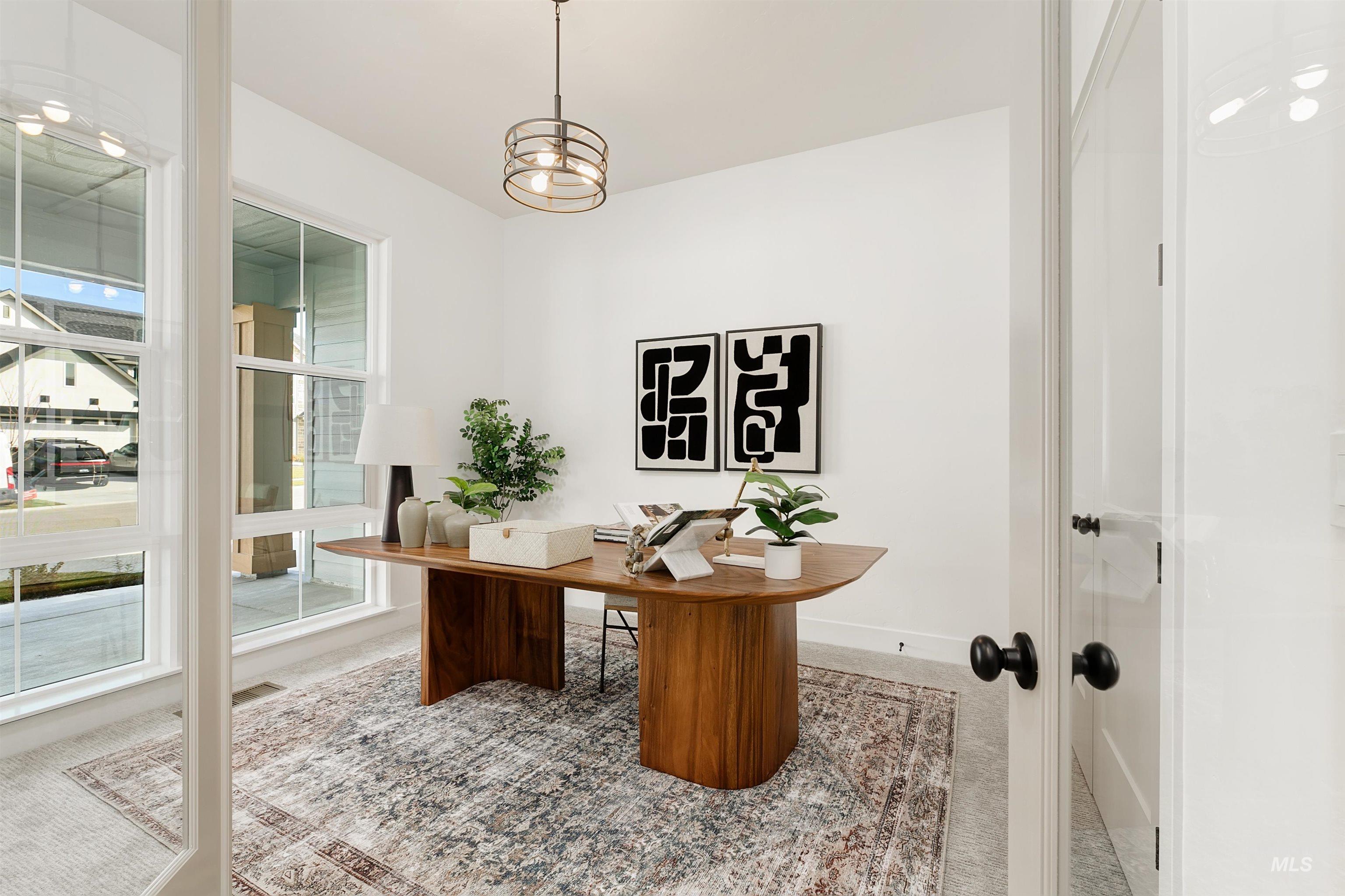 Carpeted office featuring hanging lights and baseboards