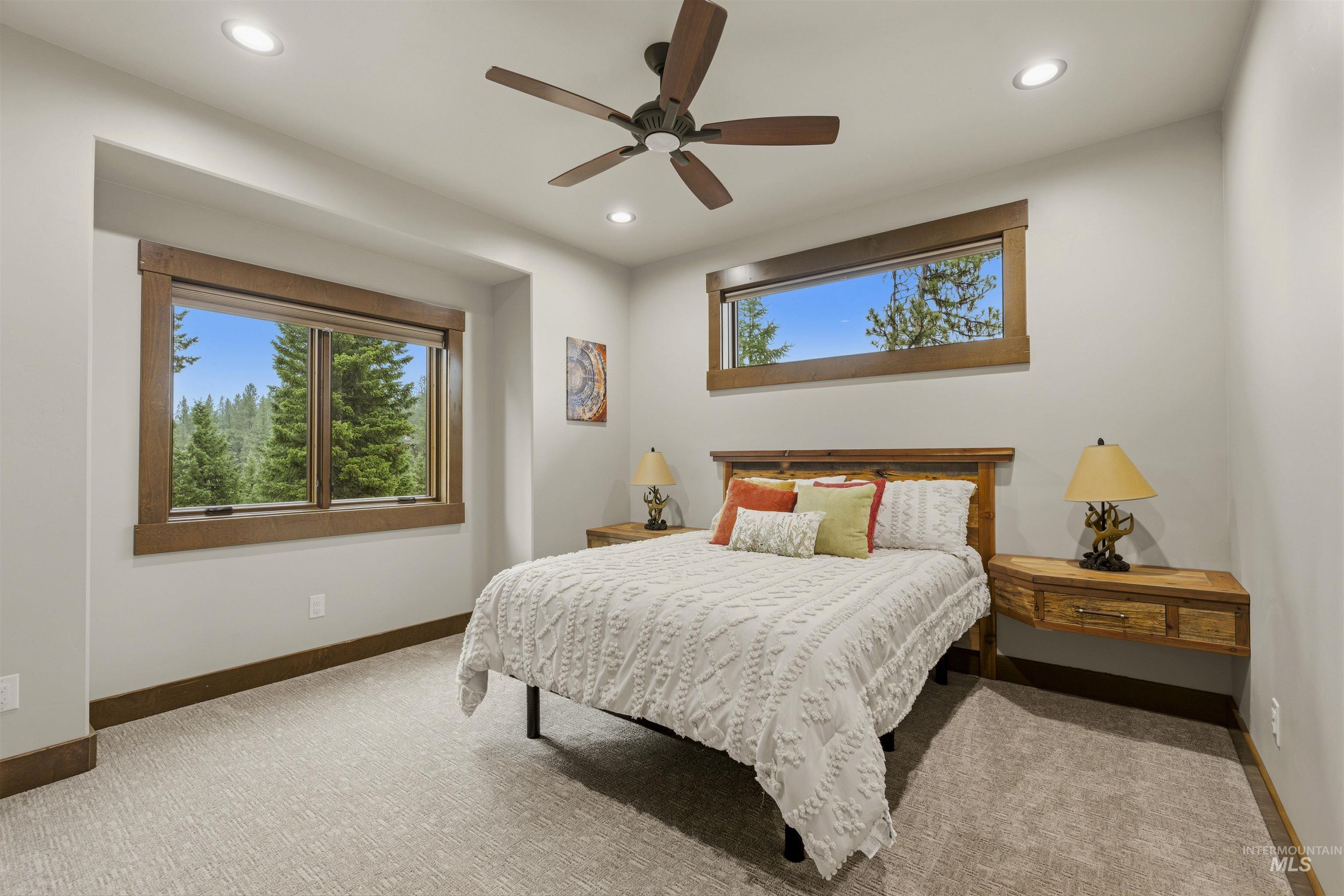 Recessed lighting illuminates this room featuring two distinct windows with wood-finish trim, a ceiling fan, and carpeted flooring - Bedroom 4, Second Level