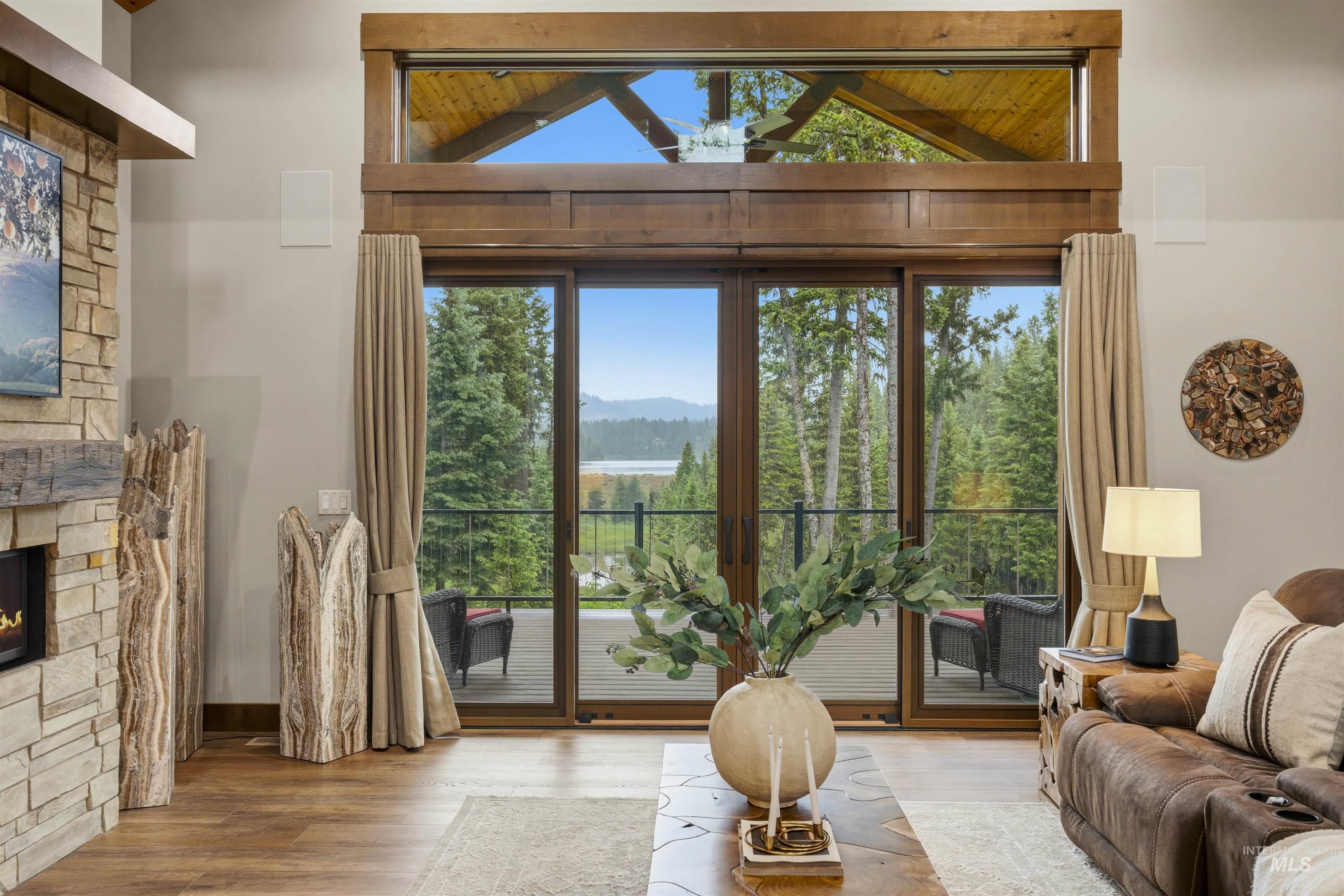 Great room featuring wood-finish flooring, a stone-clad fireplace, and a built-in media center