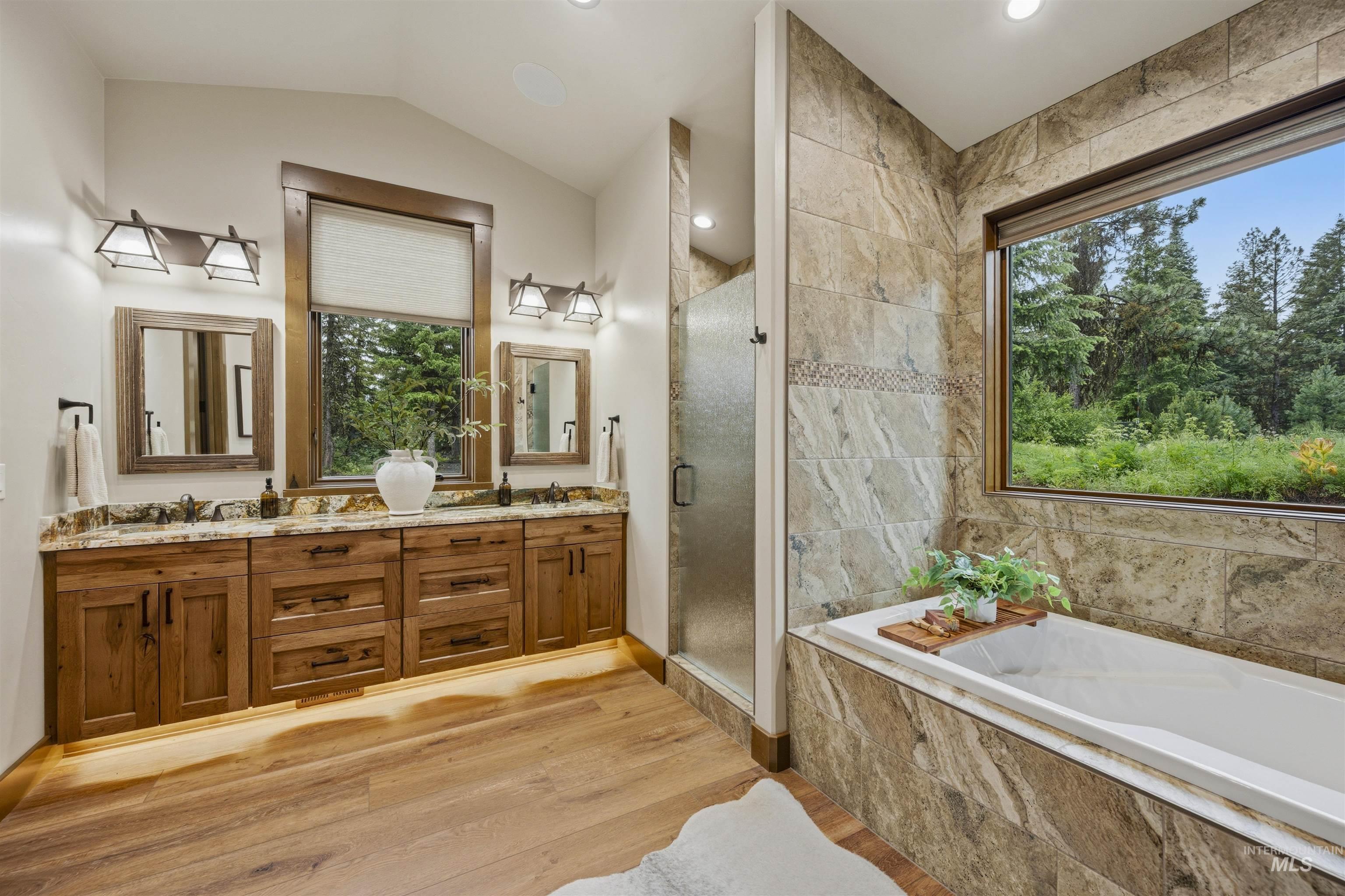Dual vanity with wood-finish cabinetry, granite countertops, and individual mirrors - Primary En Suite