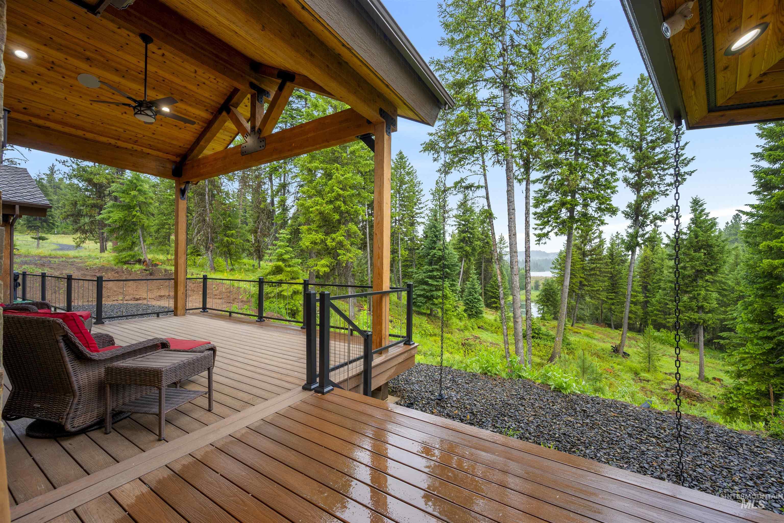 Expansive outdoor deck featuring wood-finish flooring, a covered patio with a wood-plank ceiling, and a ceiling fan with integrated lighting