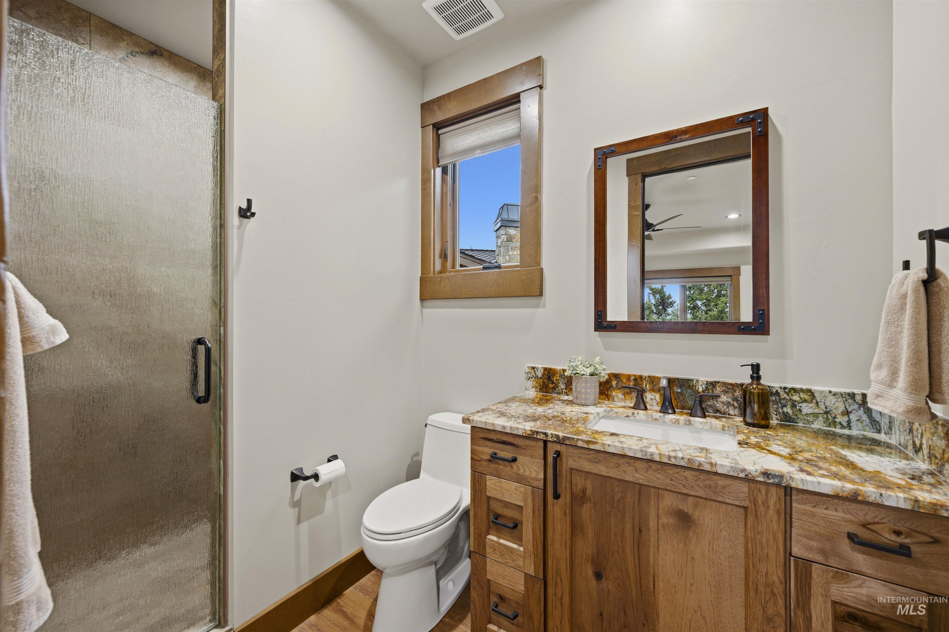 Wood-finish vanity with a colorful stone countertop and rectangular undermount sink - Ensuite to Bedroom 4