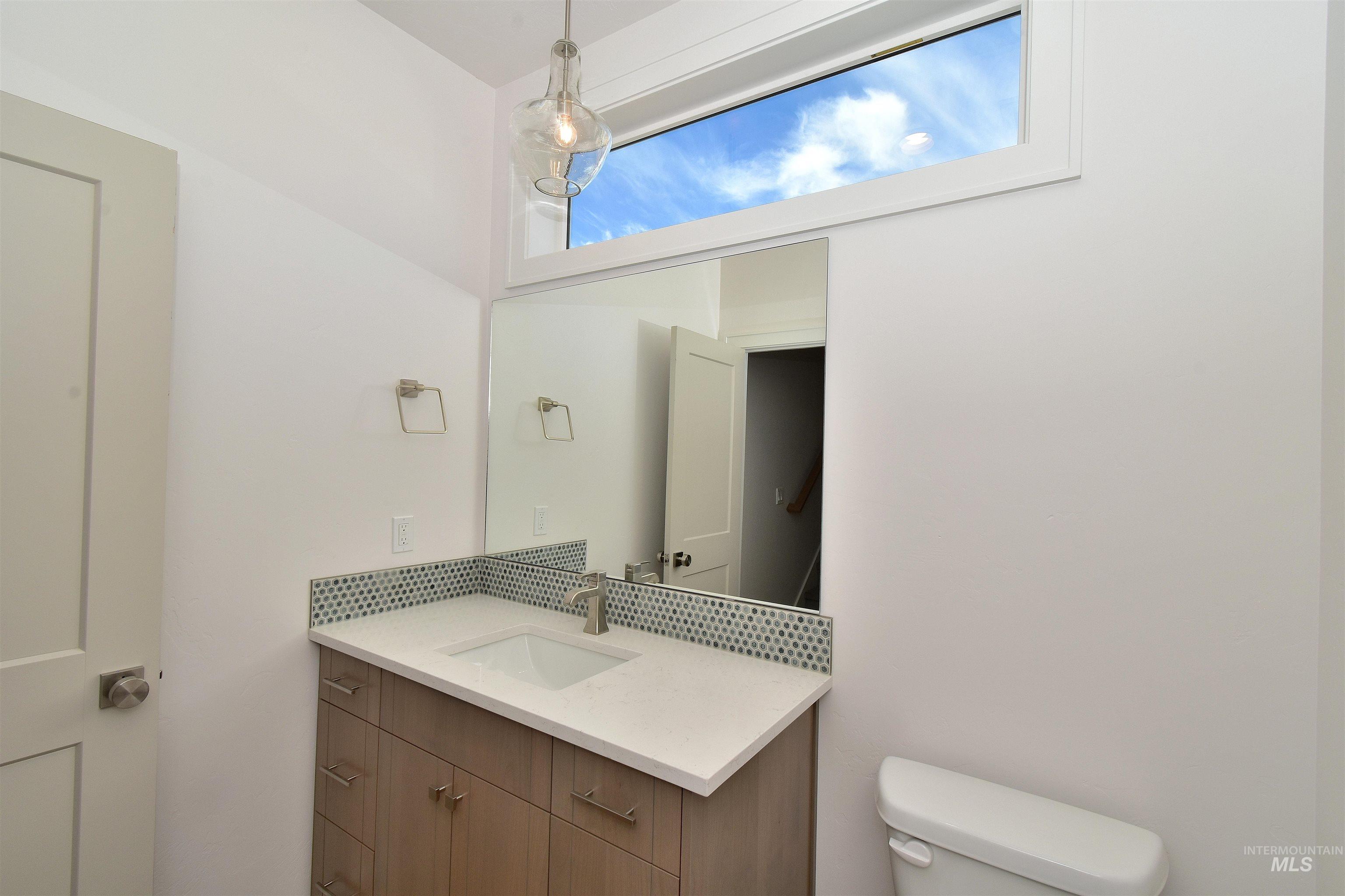 Half bathroom featuring vanity and toilet