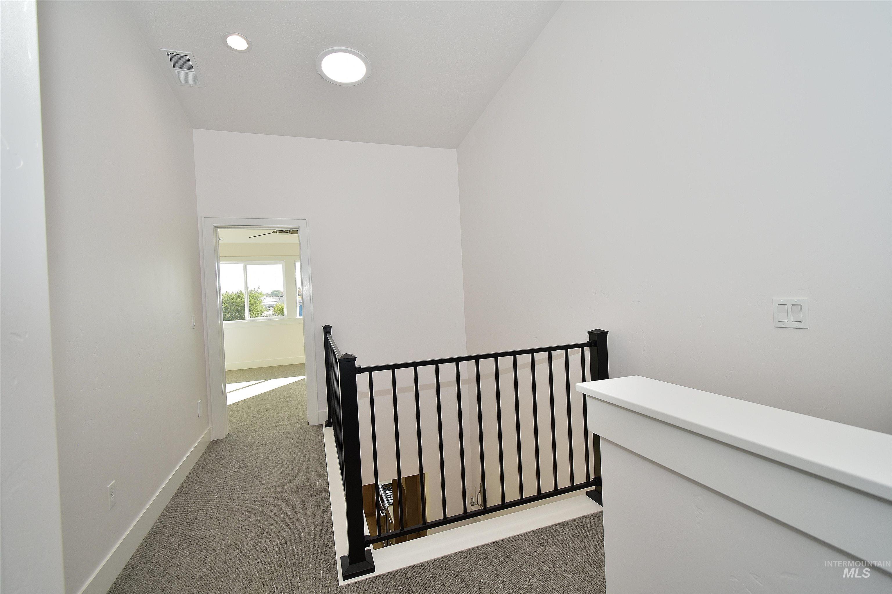 Hallway featuring carpet and an upstairs landing