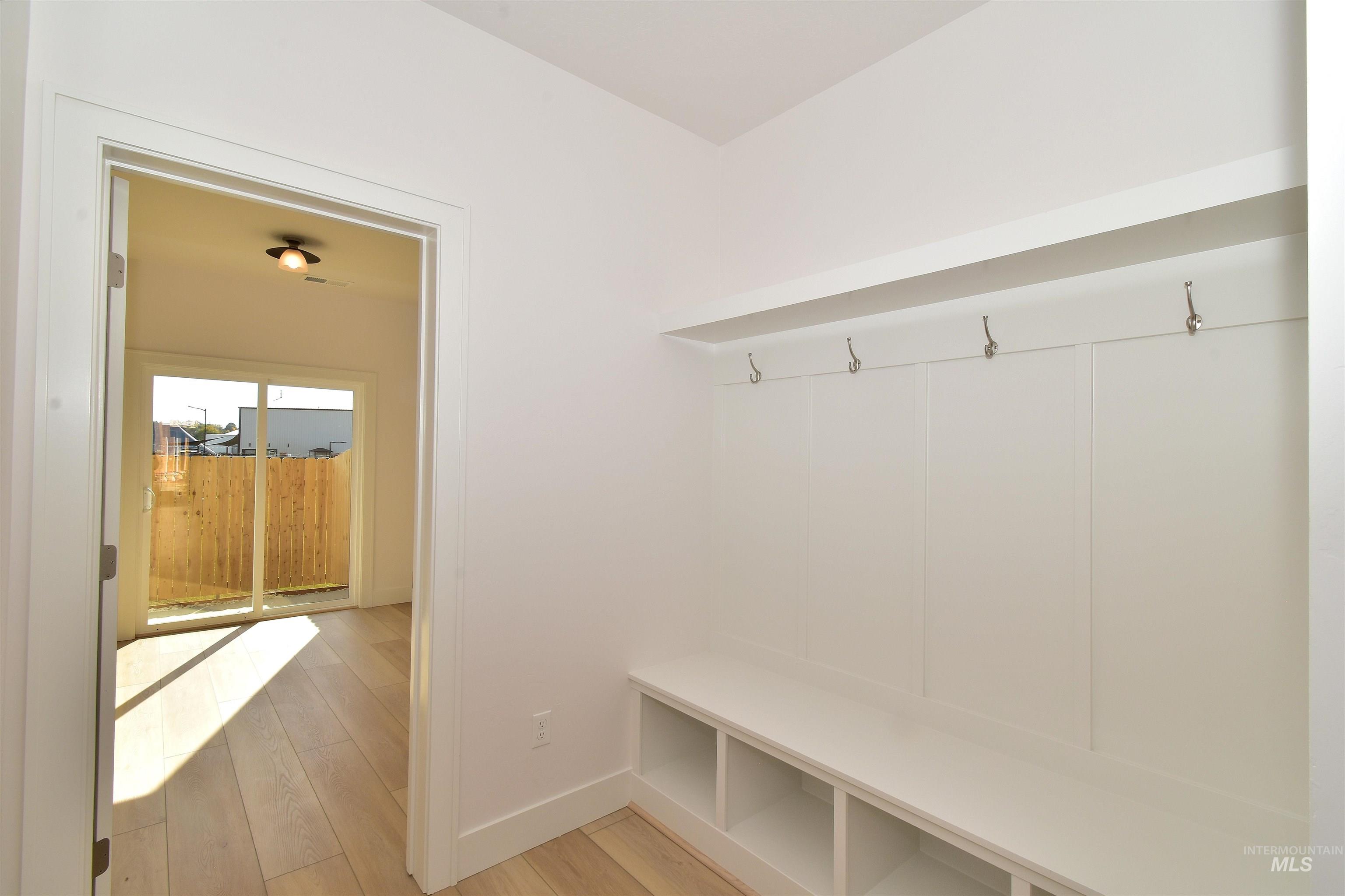 Mudroom with light wood-type flooring and baseboards