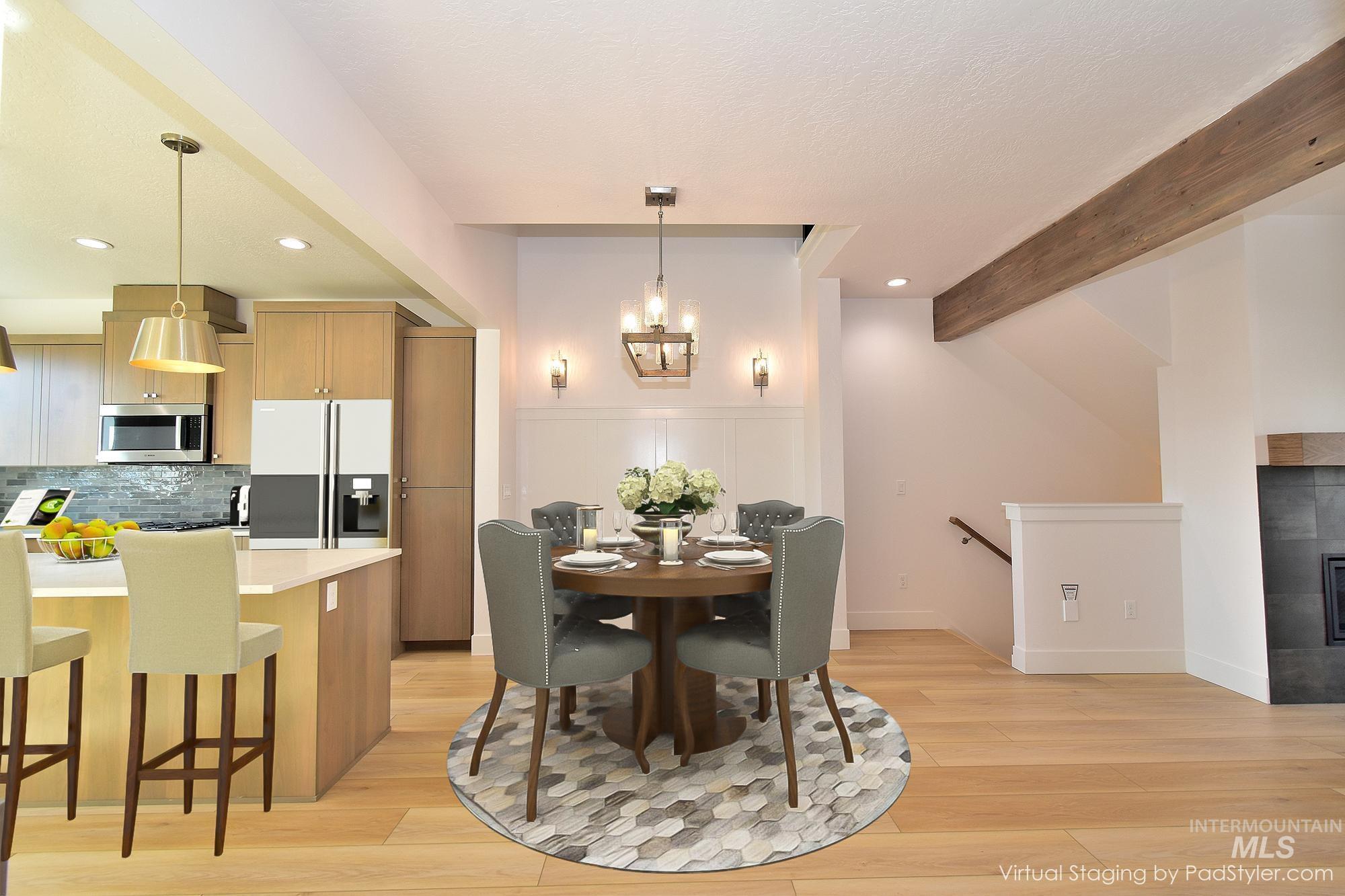 Dining space with light wood finished floors, recessed lighting, a fireplace, beam ceiling, and a chandelier