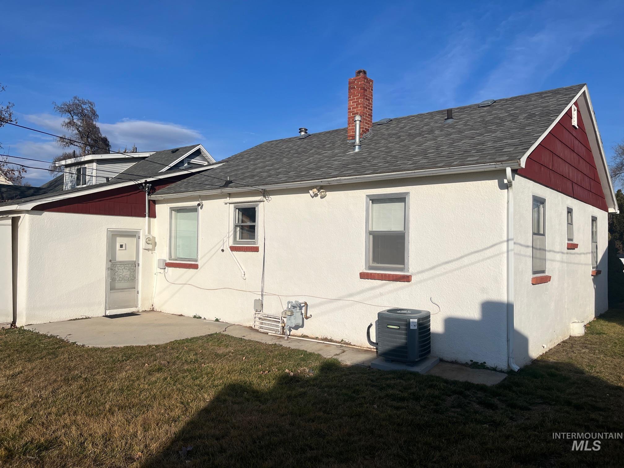Rear view of property with a lawn and a shingled roof