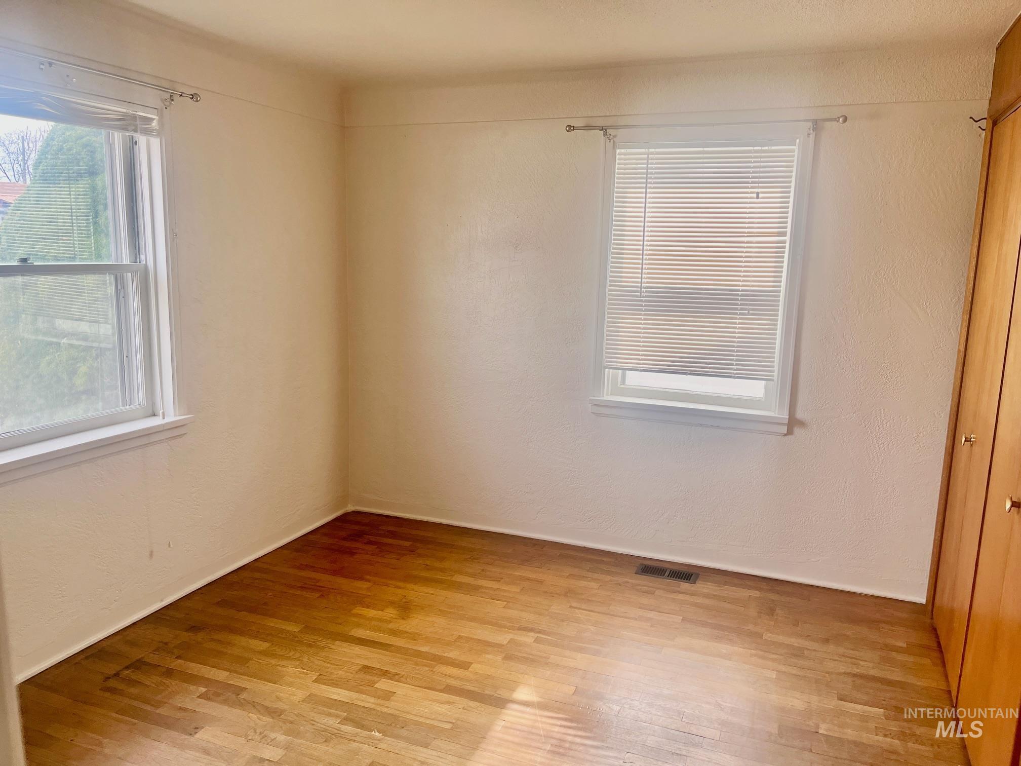 Empty room featuring a textured wall and light wood finished floors