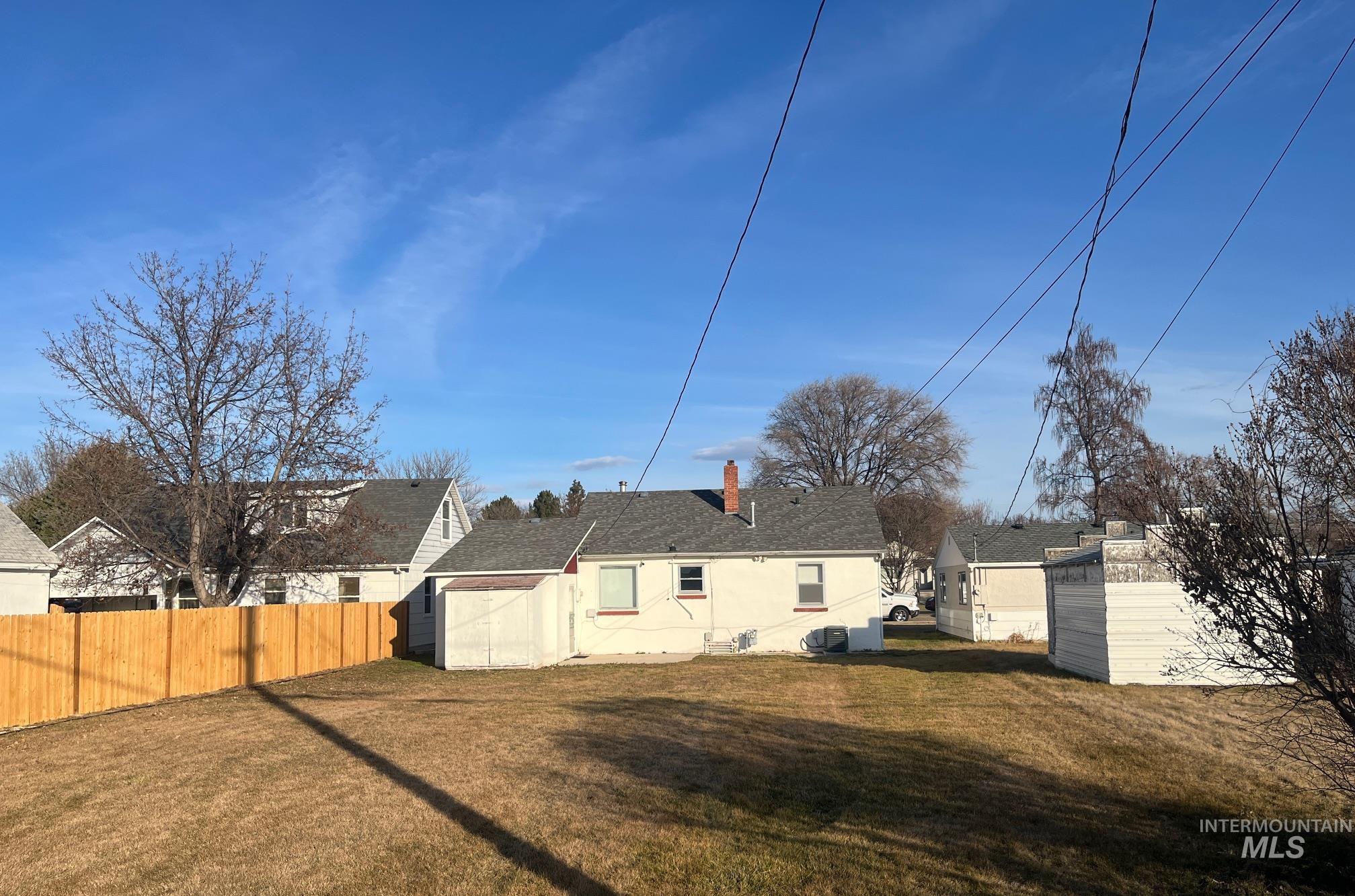Rear view of property with a storage shed, a residential view, and a chimney