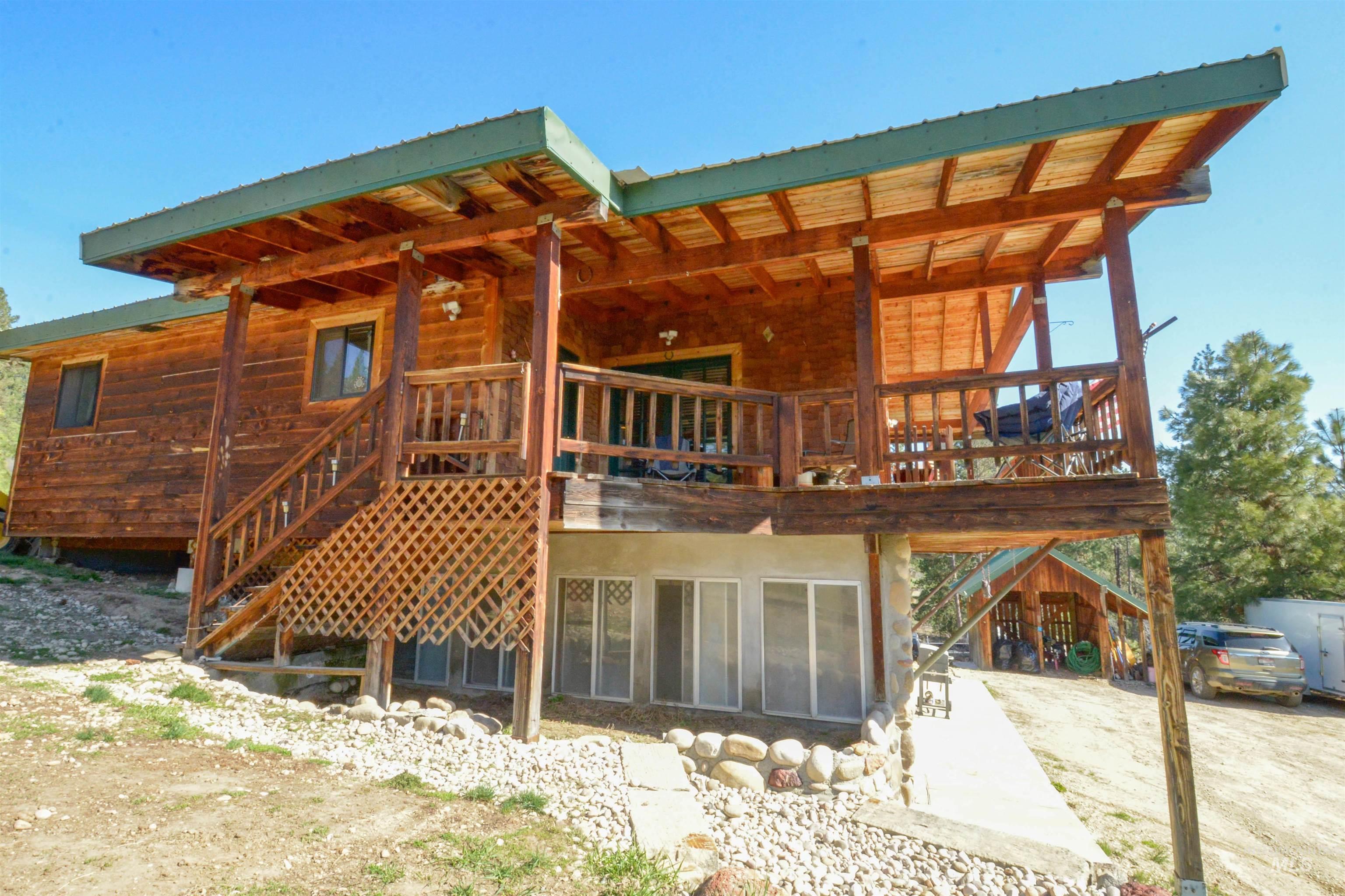 Rear view of house with stairs, a metal roof, and a wooden deck