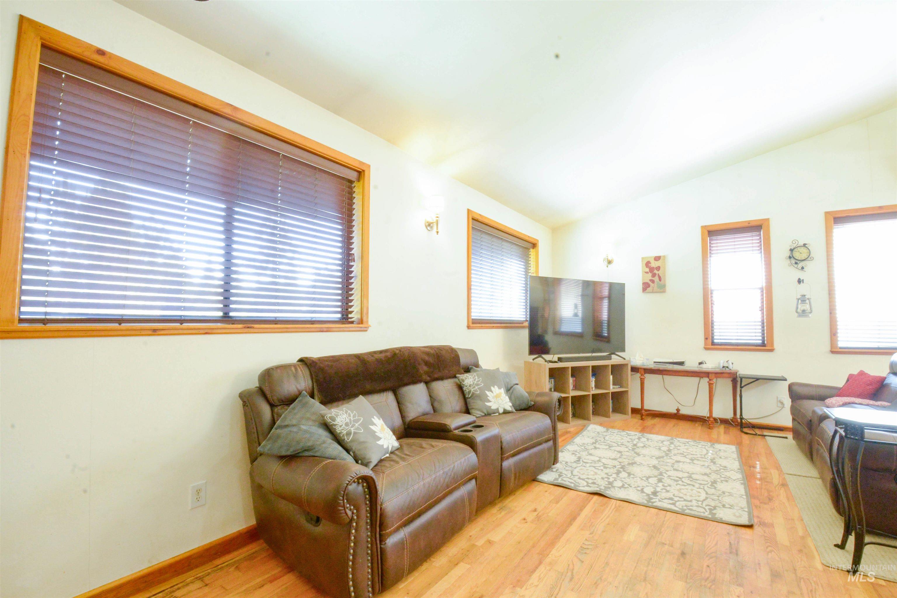 Living area with vaulted ceiling and light wood-style flooring