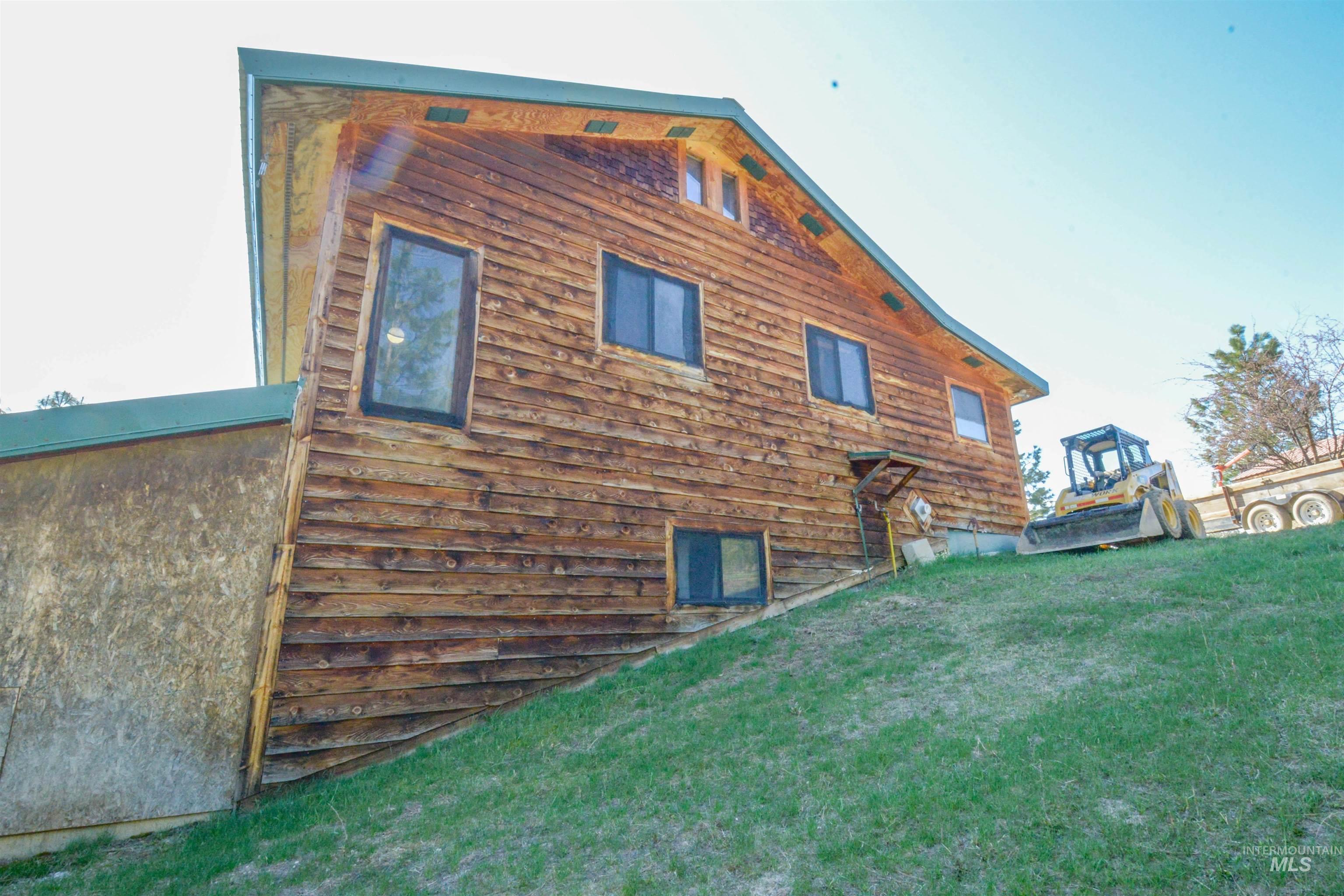 View of property exterior featuring a wooden deck and a yard