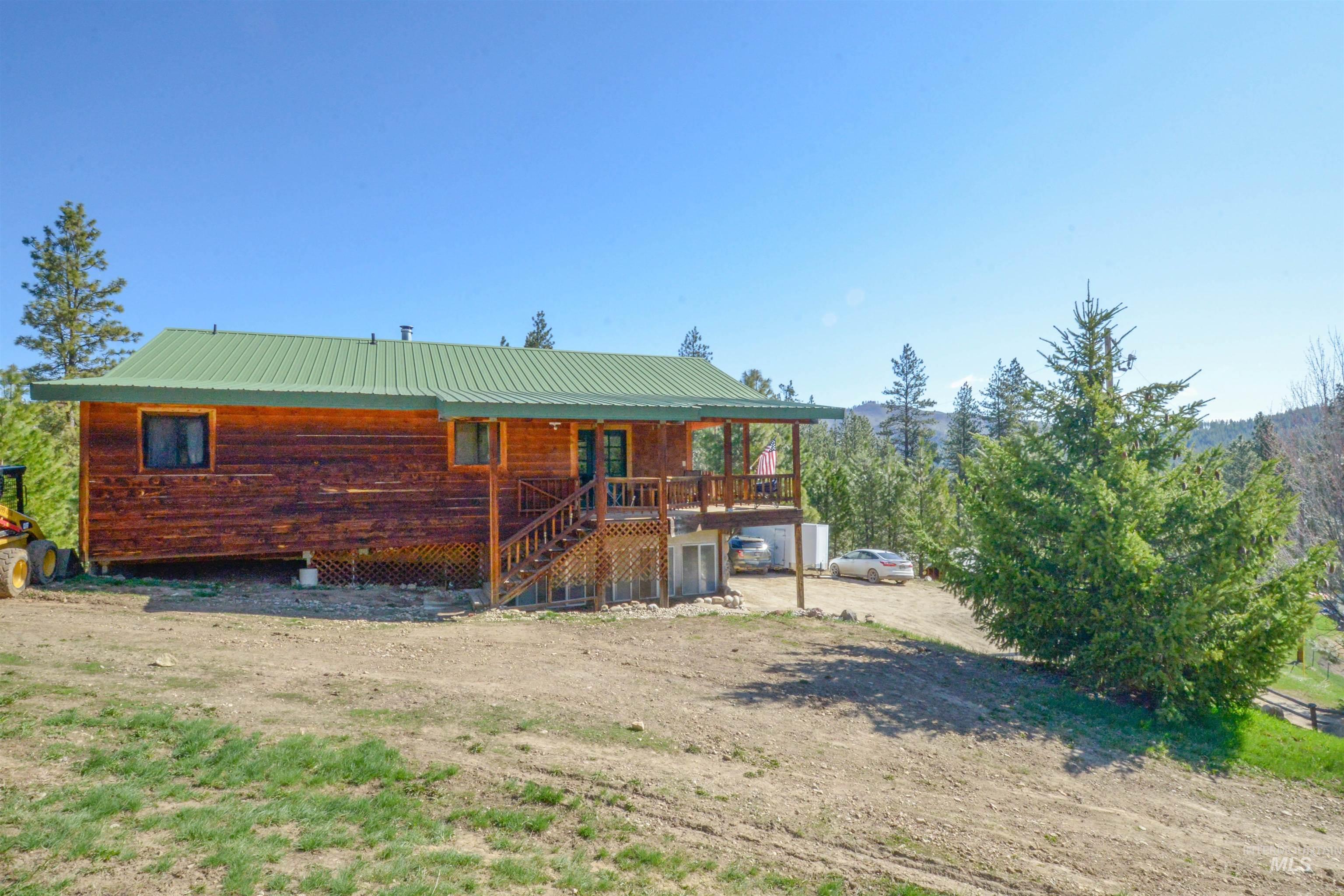 Rear view of property featuring stairs, covered porch, and a metal roof