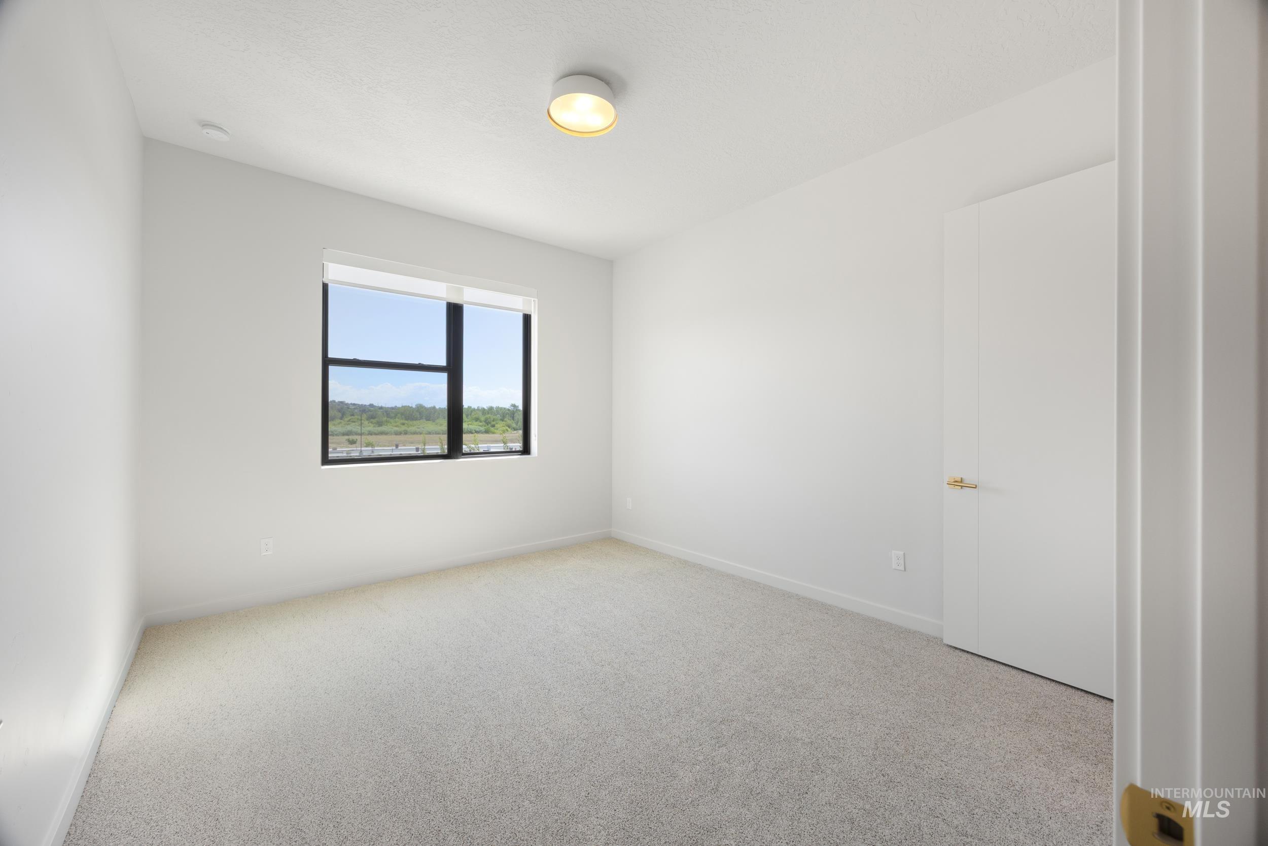 Unfurnished room featuring light colored carpet and baseboards