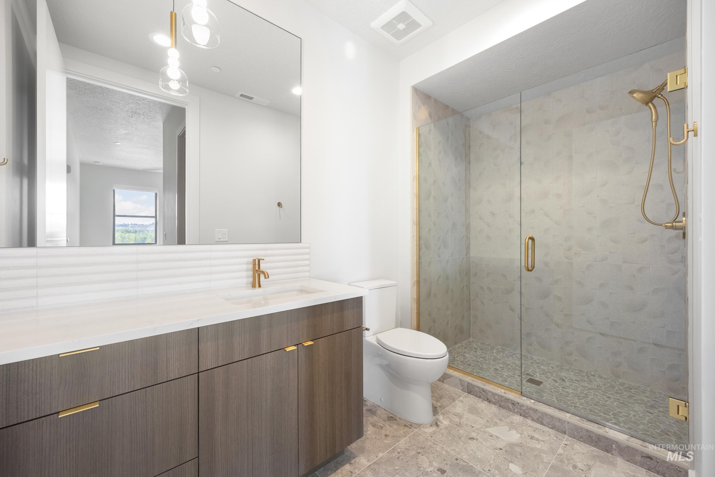 Bathroom featuring a shower stall and vanity