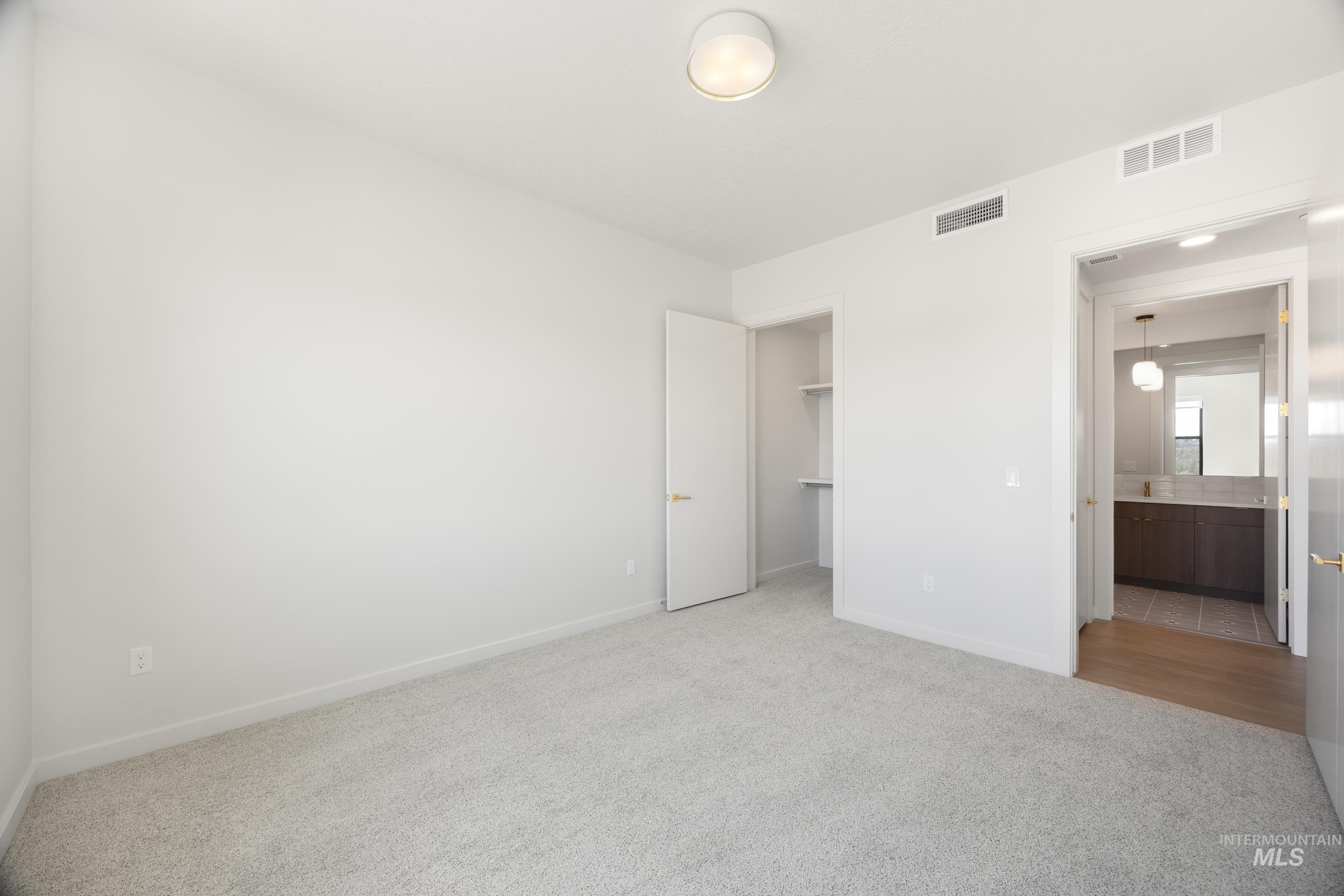 Unfurnished bedroom featuring a spacious closet and light colored carpet