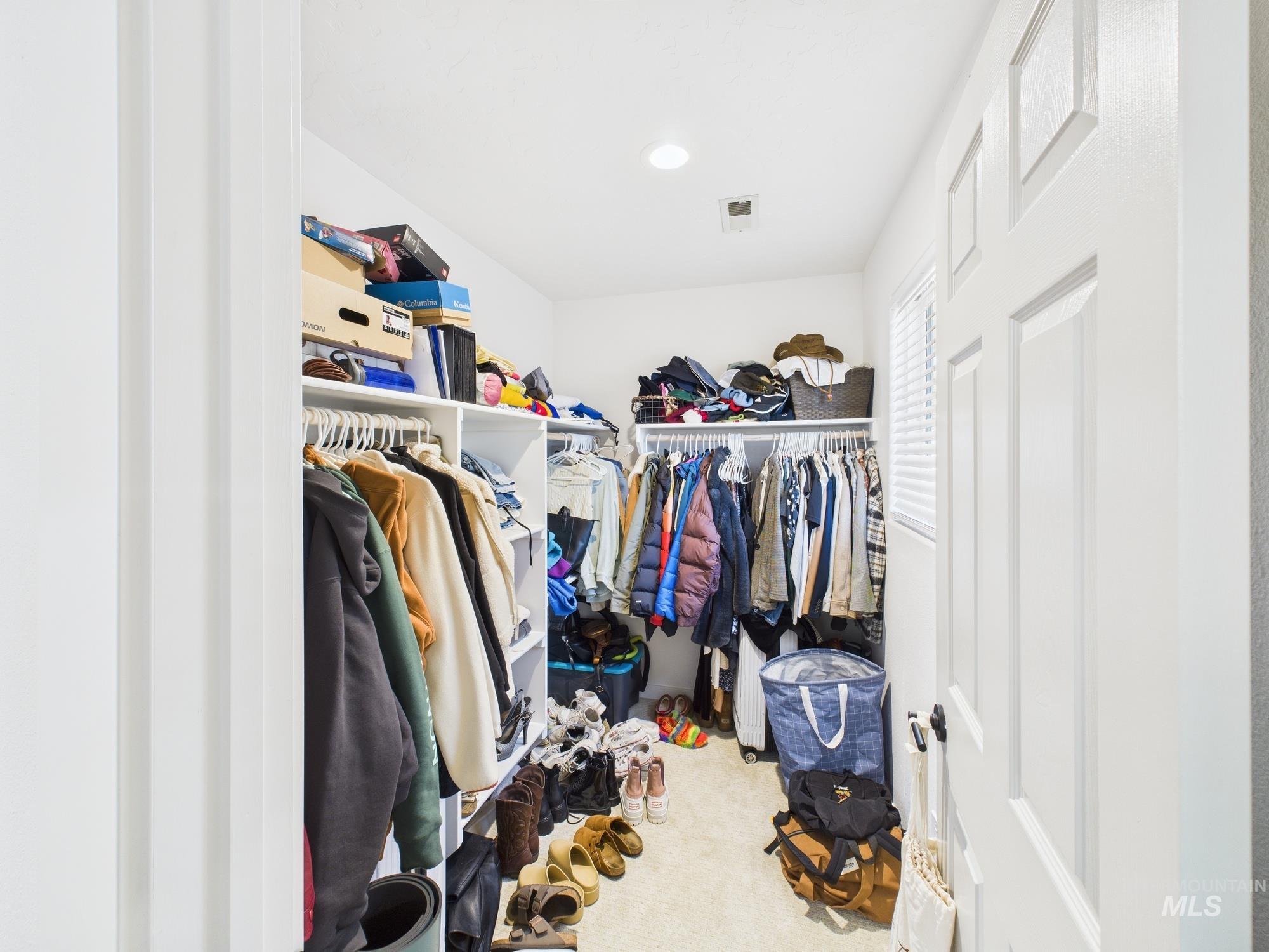 Walk in closet featuring light colored carpet