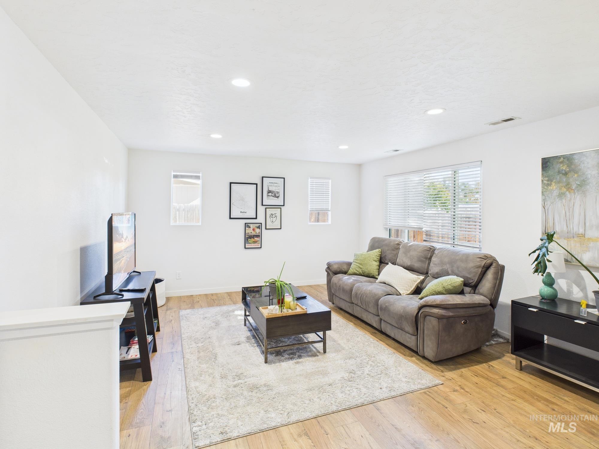 Living area with light wood-style flooring and recessed lighting