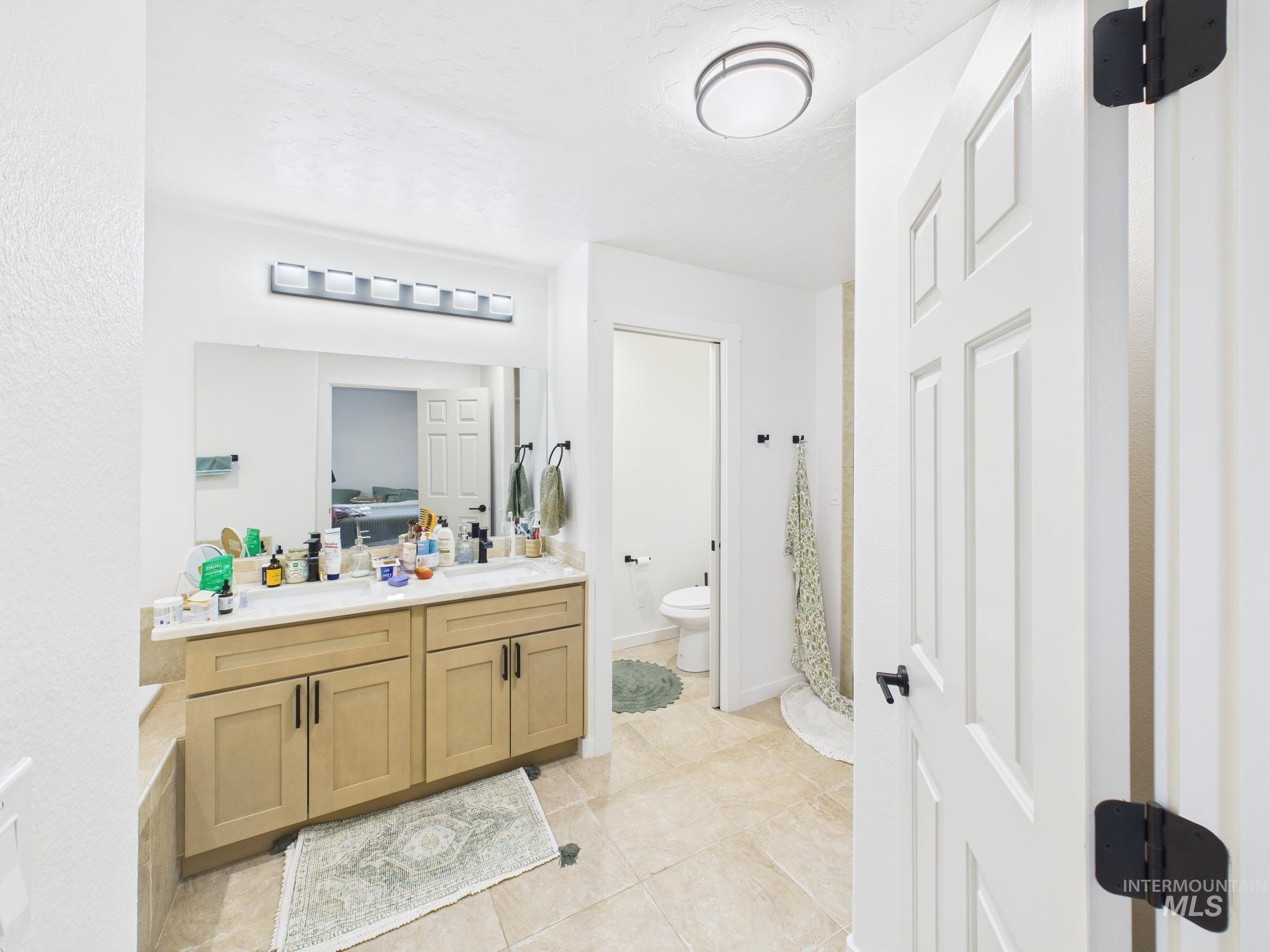 Bathroom with vanity, curtained shower, and light tile patterned flooring