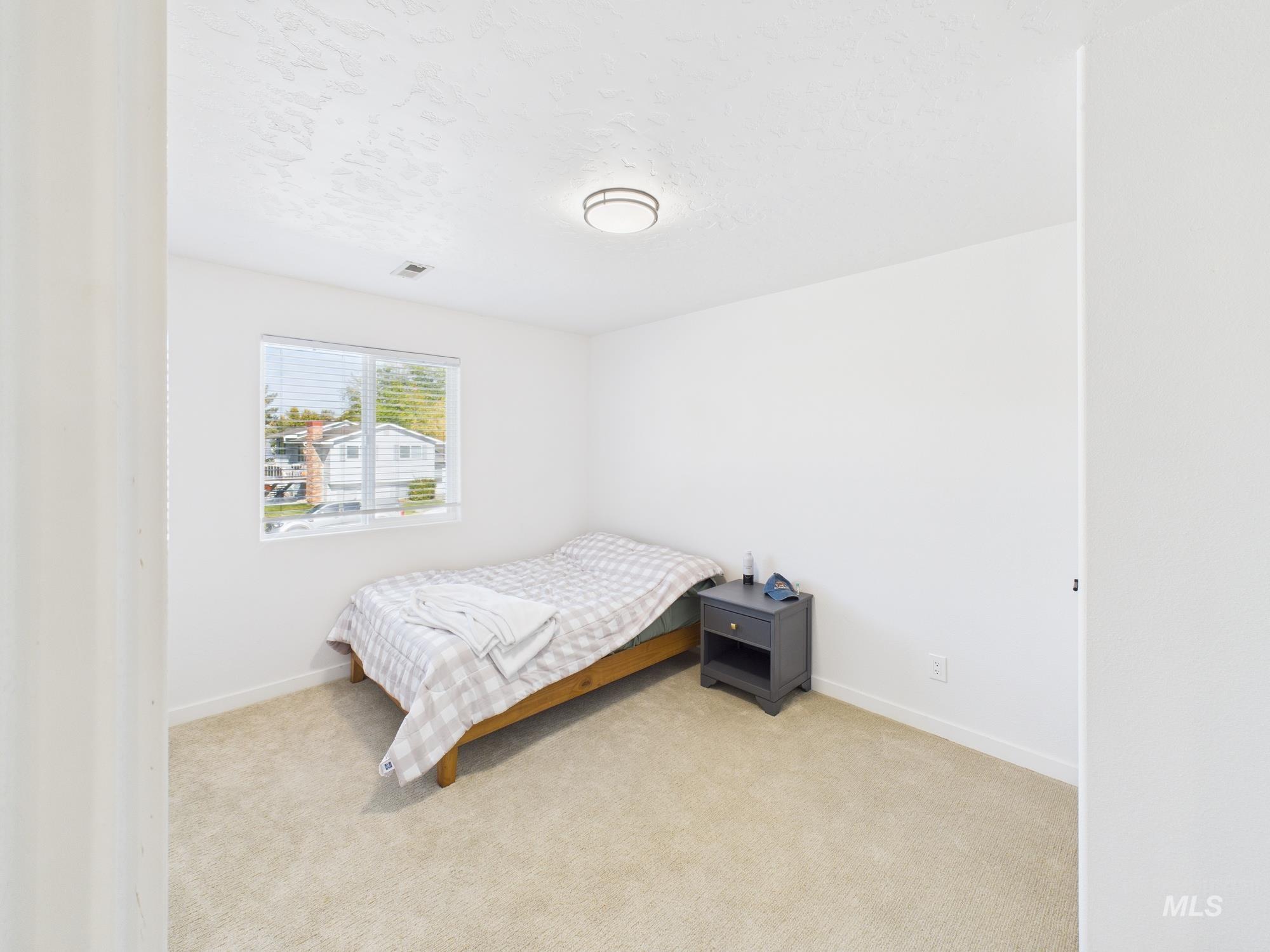 Carpeted bedroom with baseboards and a textured ceiling