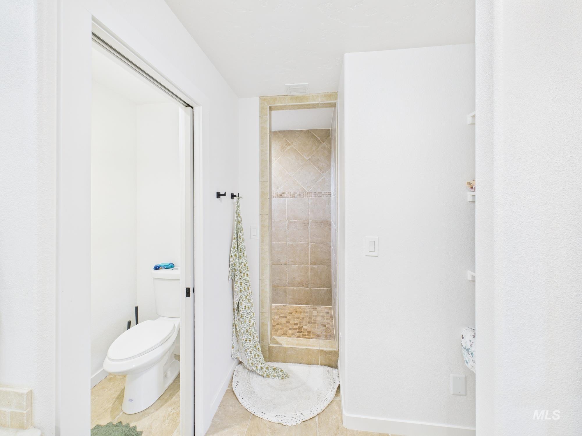 Full bathroom with a stall shower and tile patterned floors