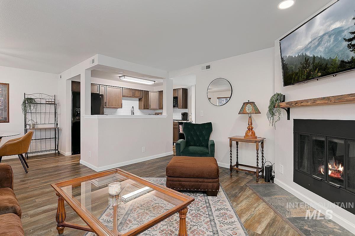 Living room with dark wood-type flooring and a glass covered fireplace
