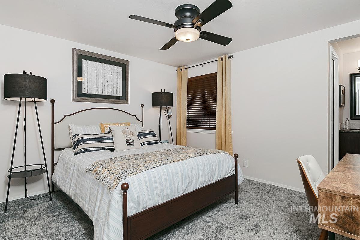 Bedroom featuring a ceiling fan, carpet flooring, and ensuite bathroom