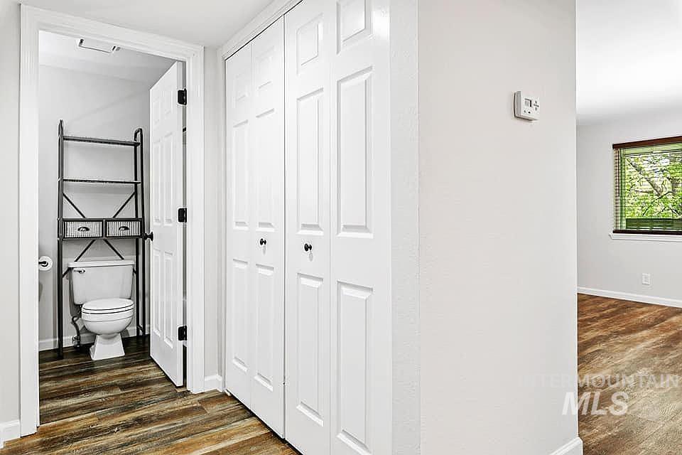 Bathroom featuring dark wood-style floors and a closet