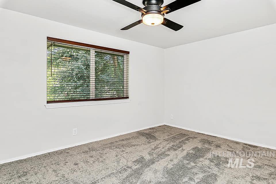 Spare room featuring carpet flooring and ceiling fan