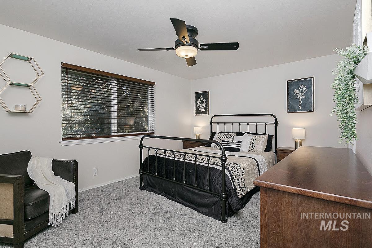 Bedroom with light colored carpet and a ceiling fan