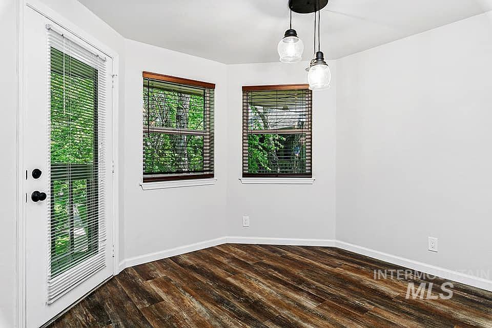 Unfurnished room with dark wood-style floors and baseboards