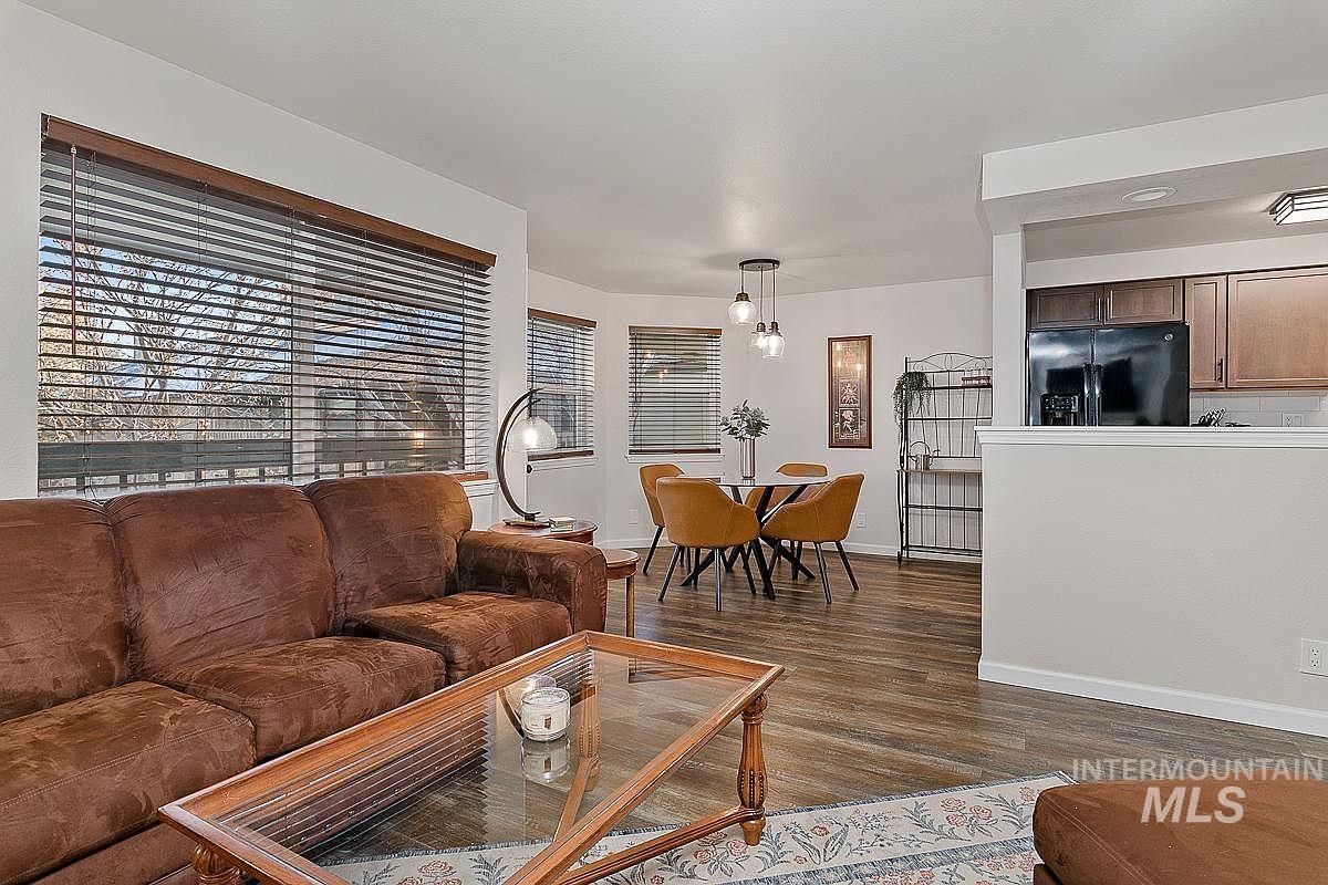 Living room featuring dark wood finished floors and baseboards