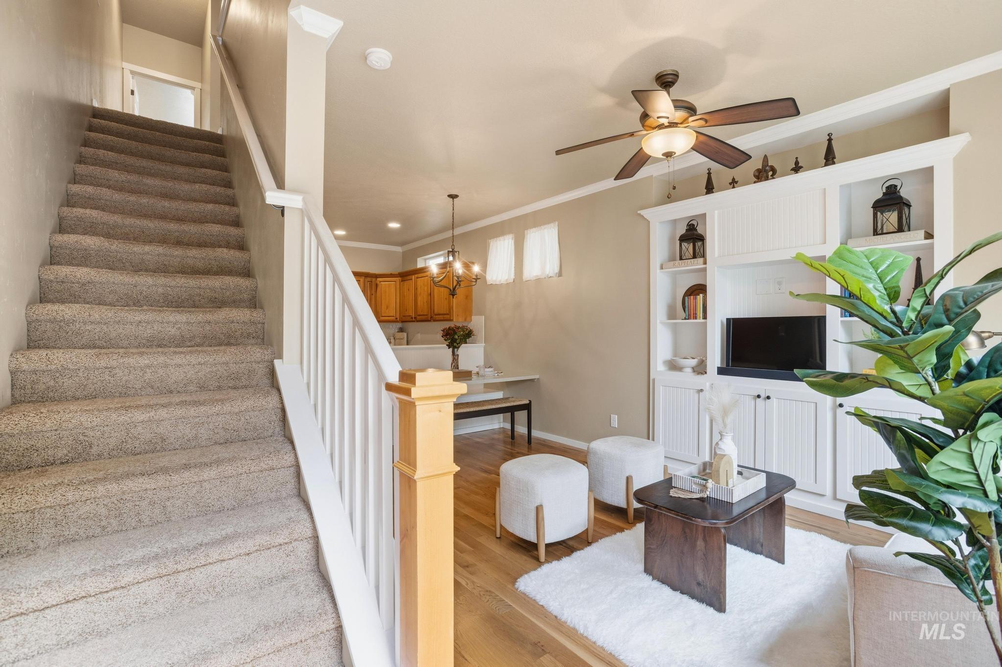 Carpeted staircase with white balusters and a light wood newel post