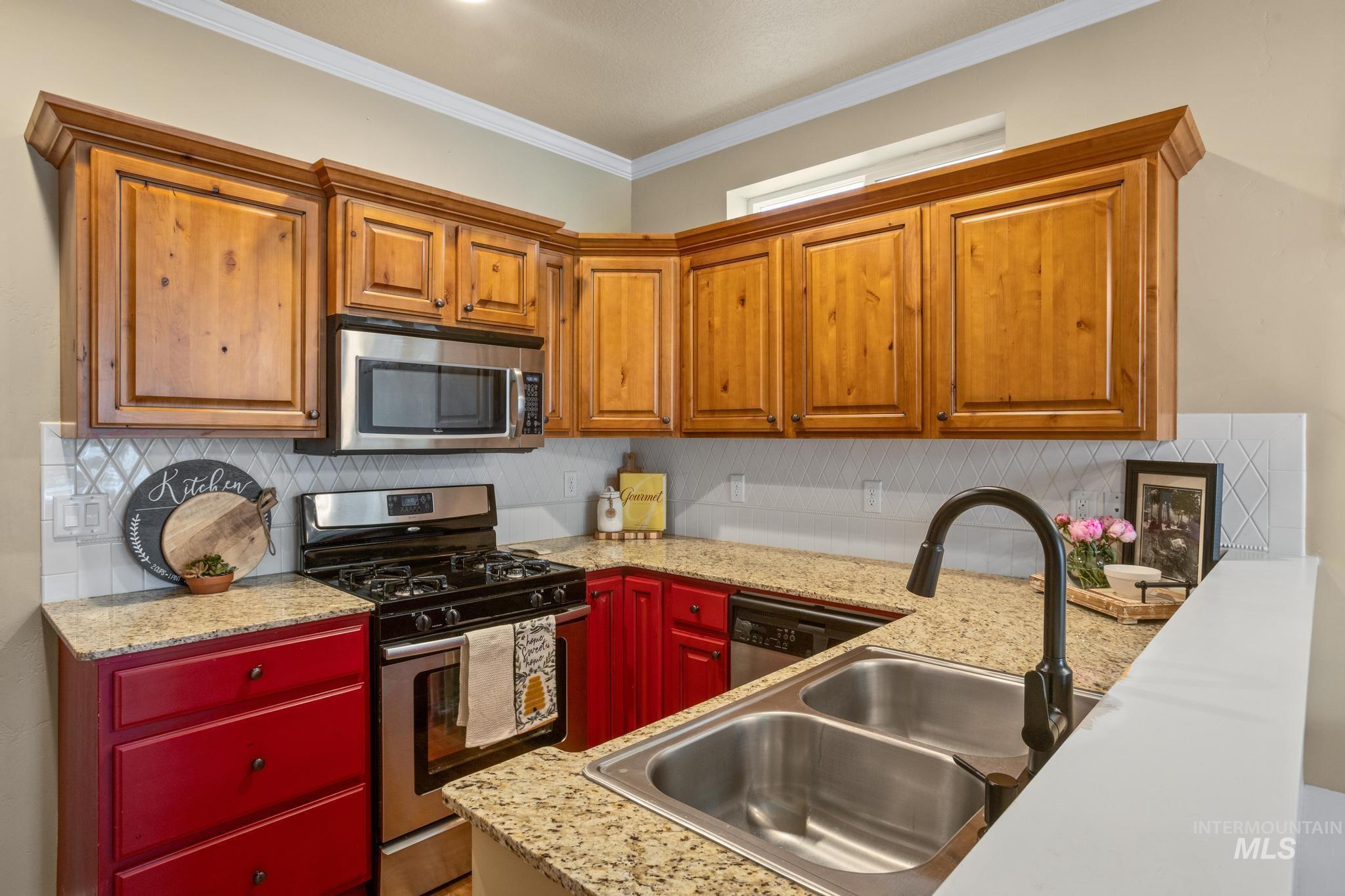 Kitchen featuring light wood cabinetry with crown molding, granite-style countertops, and a white subway tile backsplash