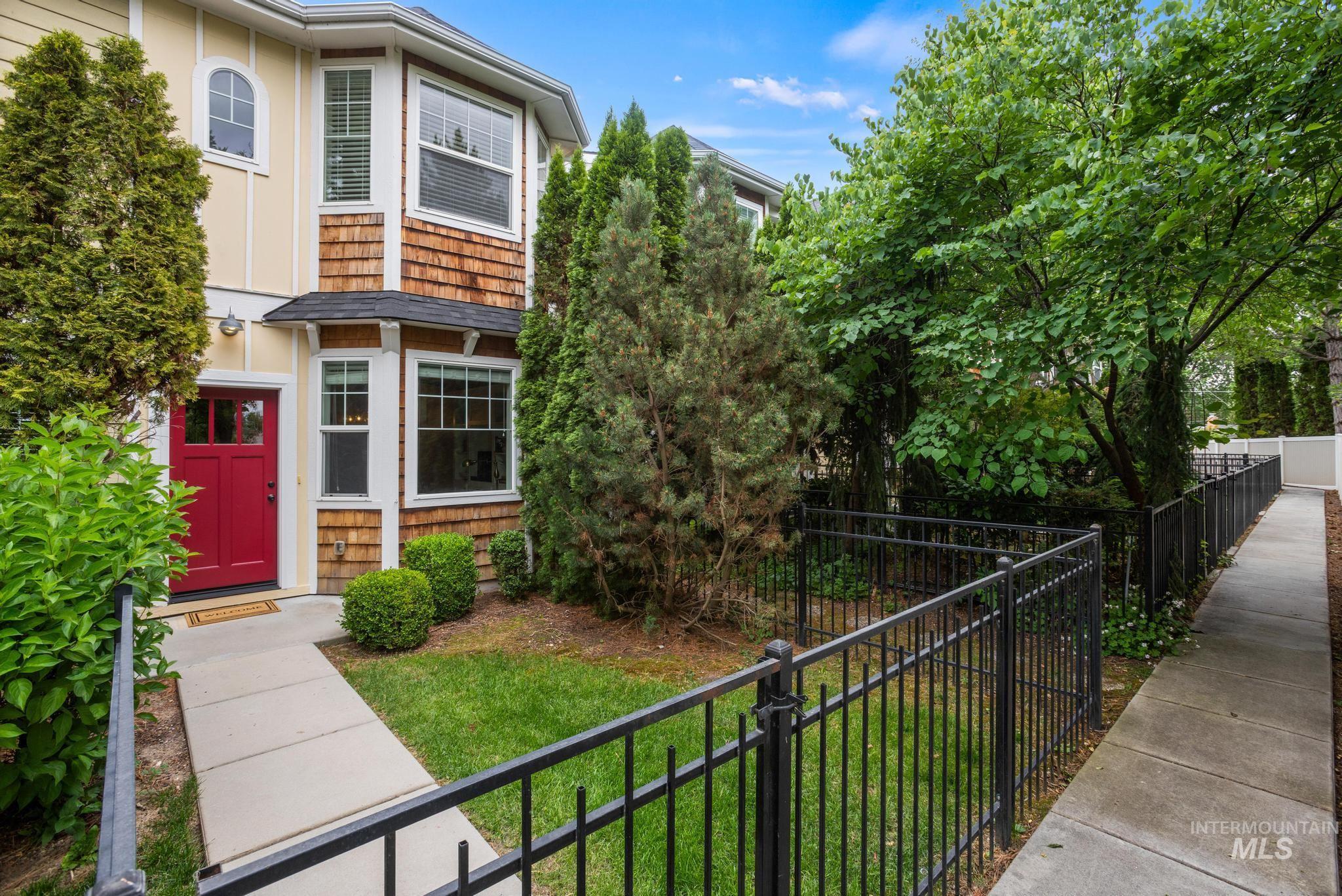 Exterior features include a striking red entry door, cedar shake siding accents, and a bay window