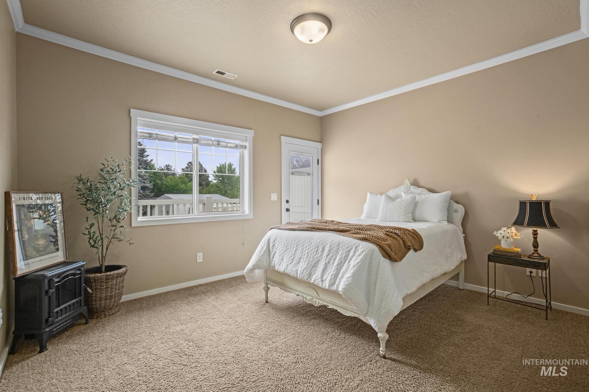 Carpeted room with a large window and exterior door
