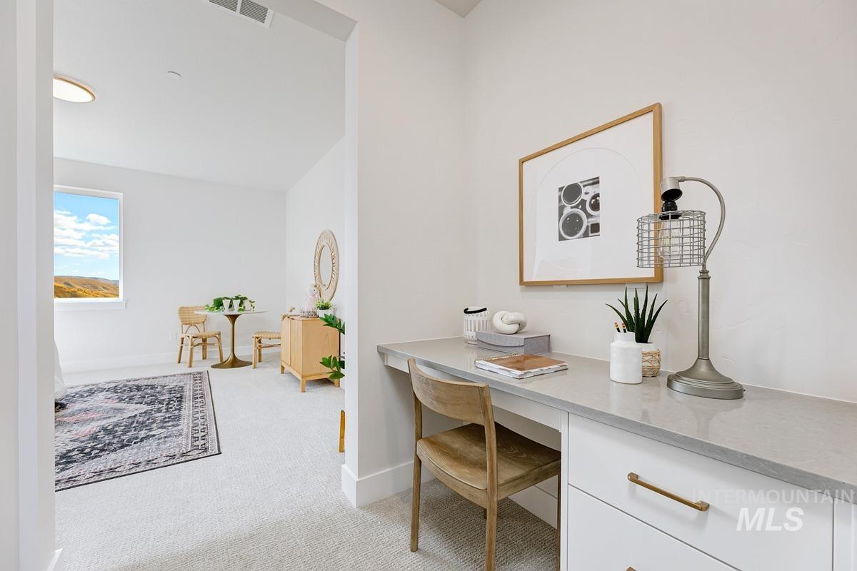 Office space with light carpet and built in study area