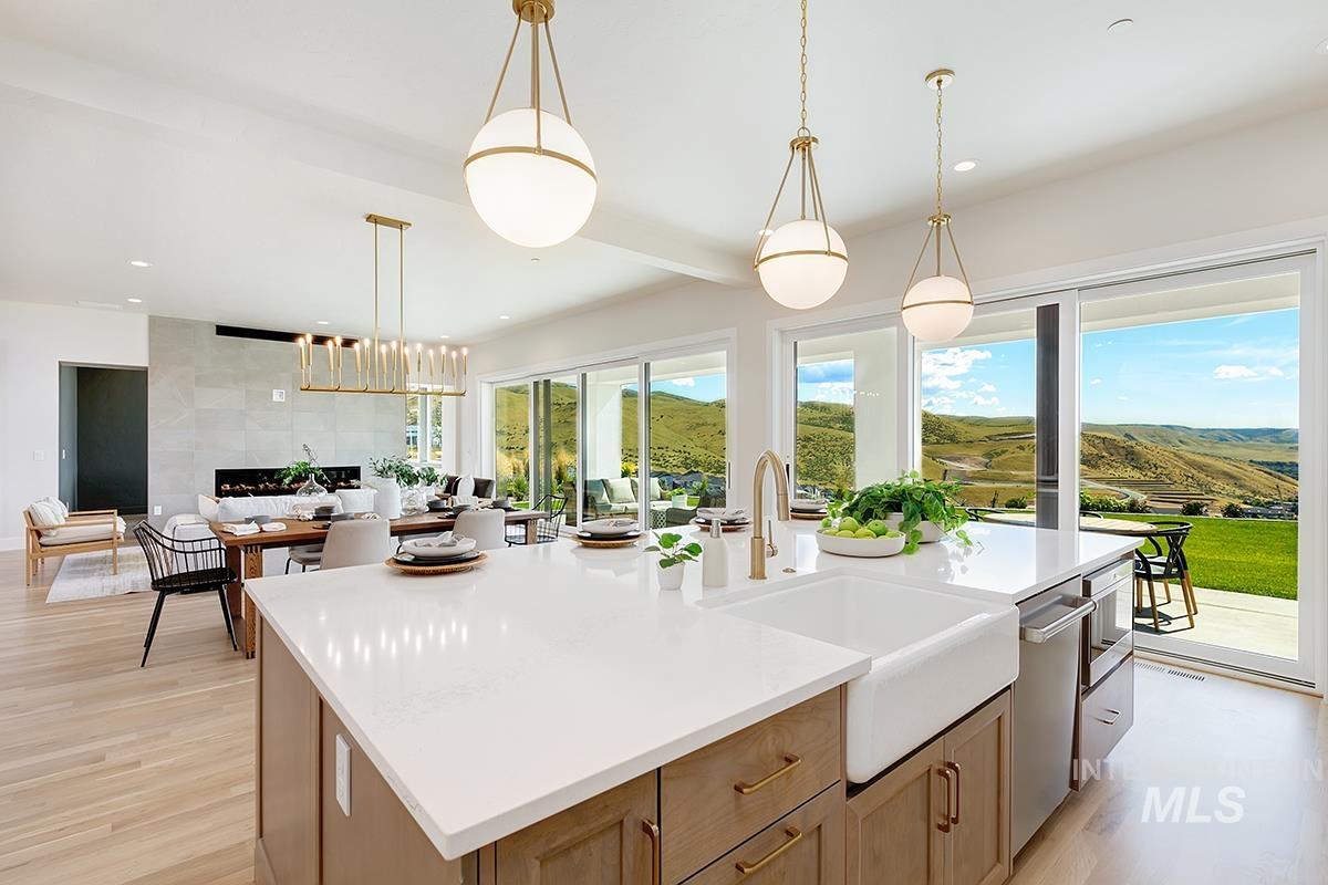 Kitchen with pendant lighting, an island with sink, light brown cabinetry, light wood-style floors, and recessed lighting