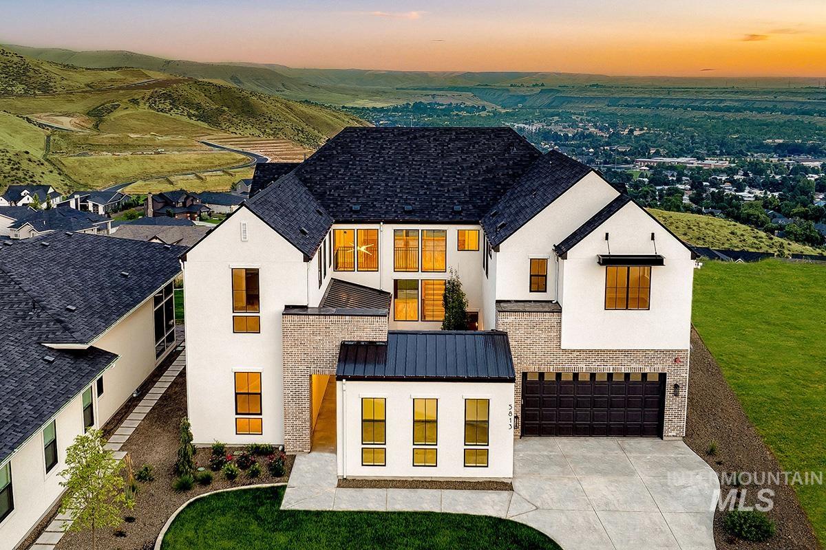 View of front of home with stucco siding, a standing seam roof, a garage, and a metal roof