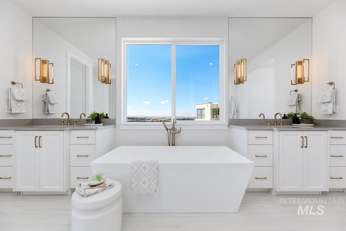 Full bathroom featuring two vanities and a soaking tub