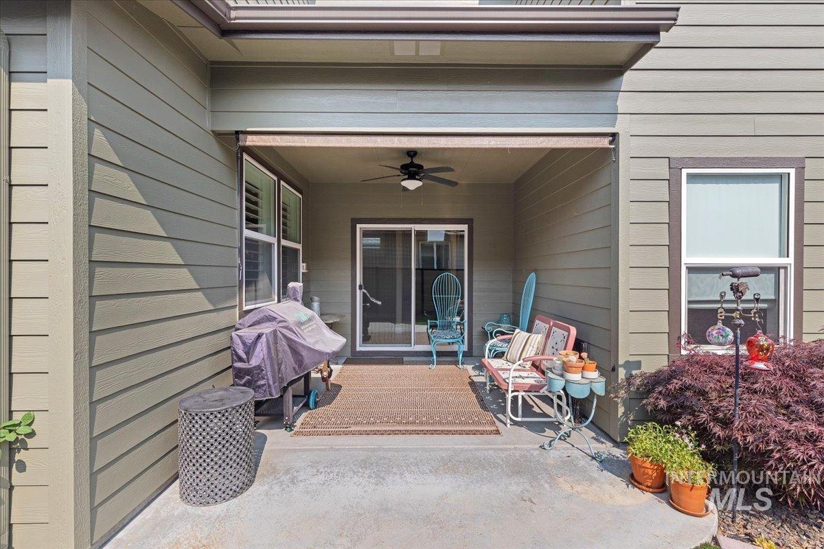 Entrance to property with a ceiling fan and a patio area