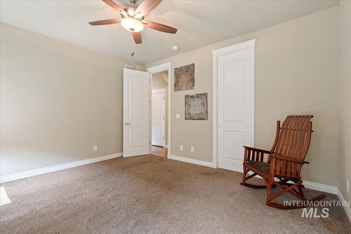 Carpeted bedroom featuring baseboards and ceiling fan