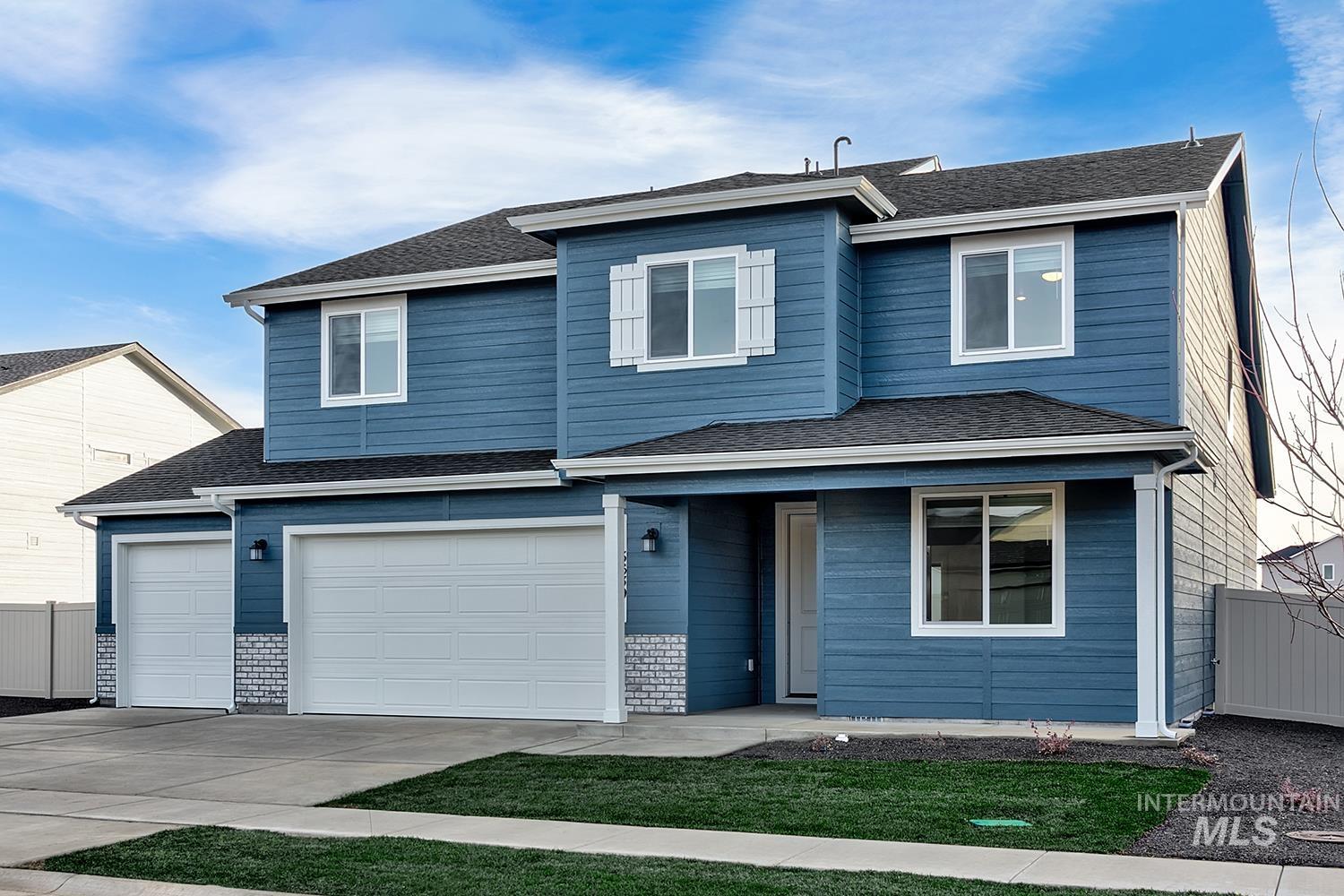 Traditional-style house with concrete driveway, roof with shingles, and a garage