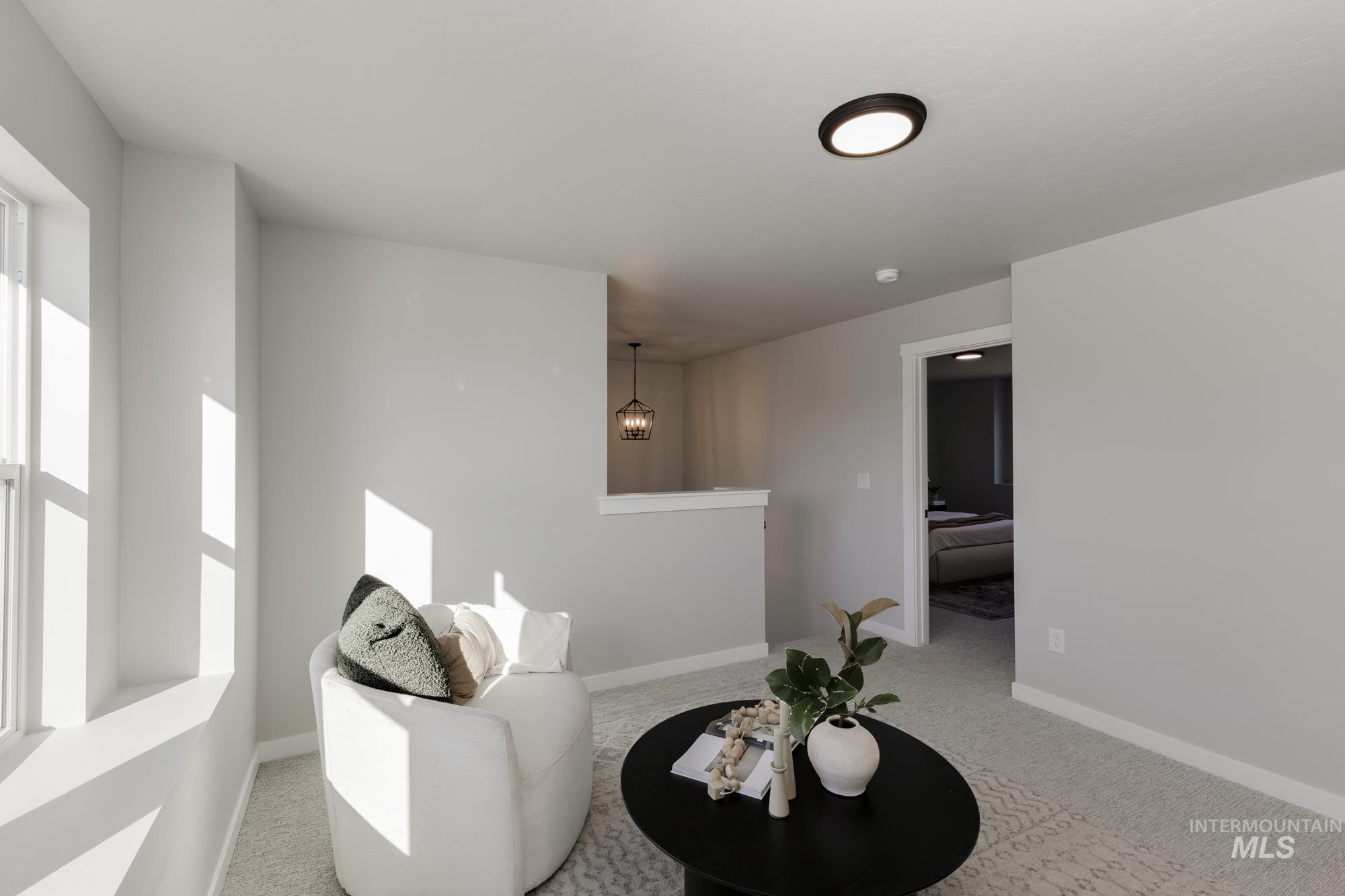 Living area featuring light carpet and baseboards