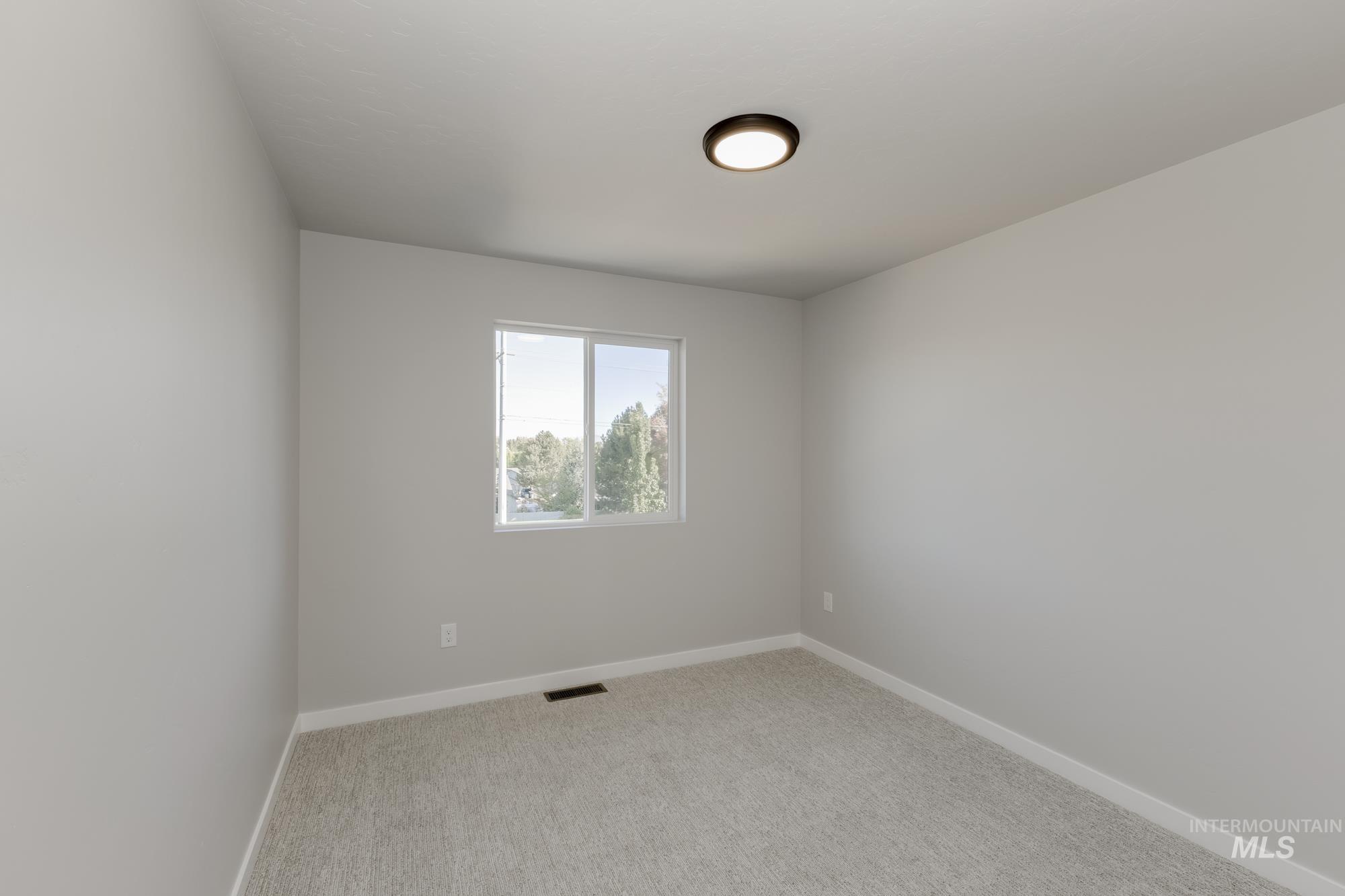 Unfurnished room with baseboards and light colored carpet
